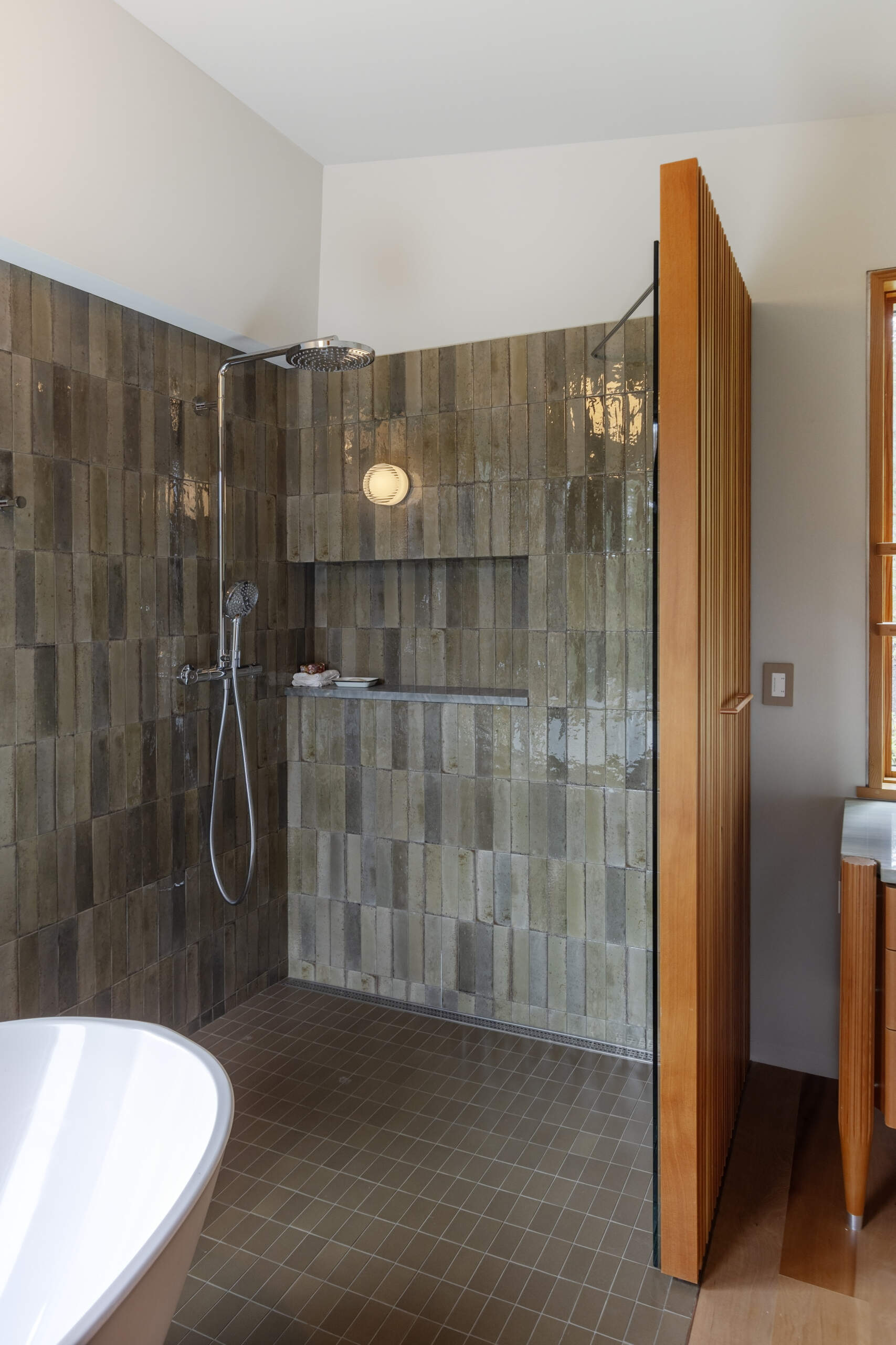 Fluted wood vanities, slatted screens, and warm natural finishes give this bathroom a refined mountain cabin feel.
