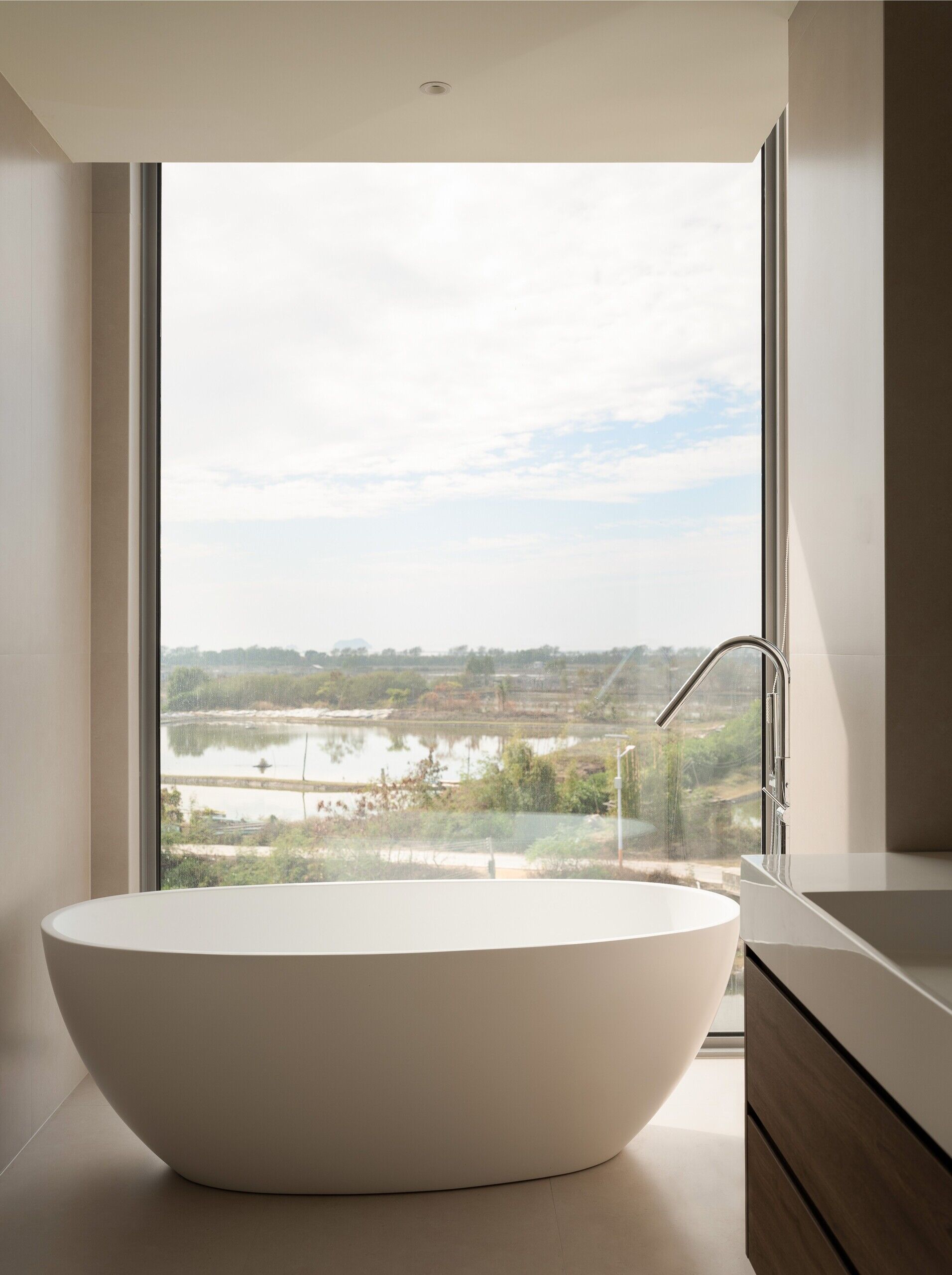 A modern bathroom with a full-height picture window.