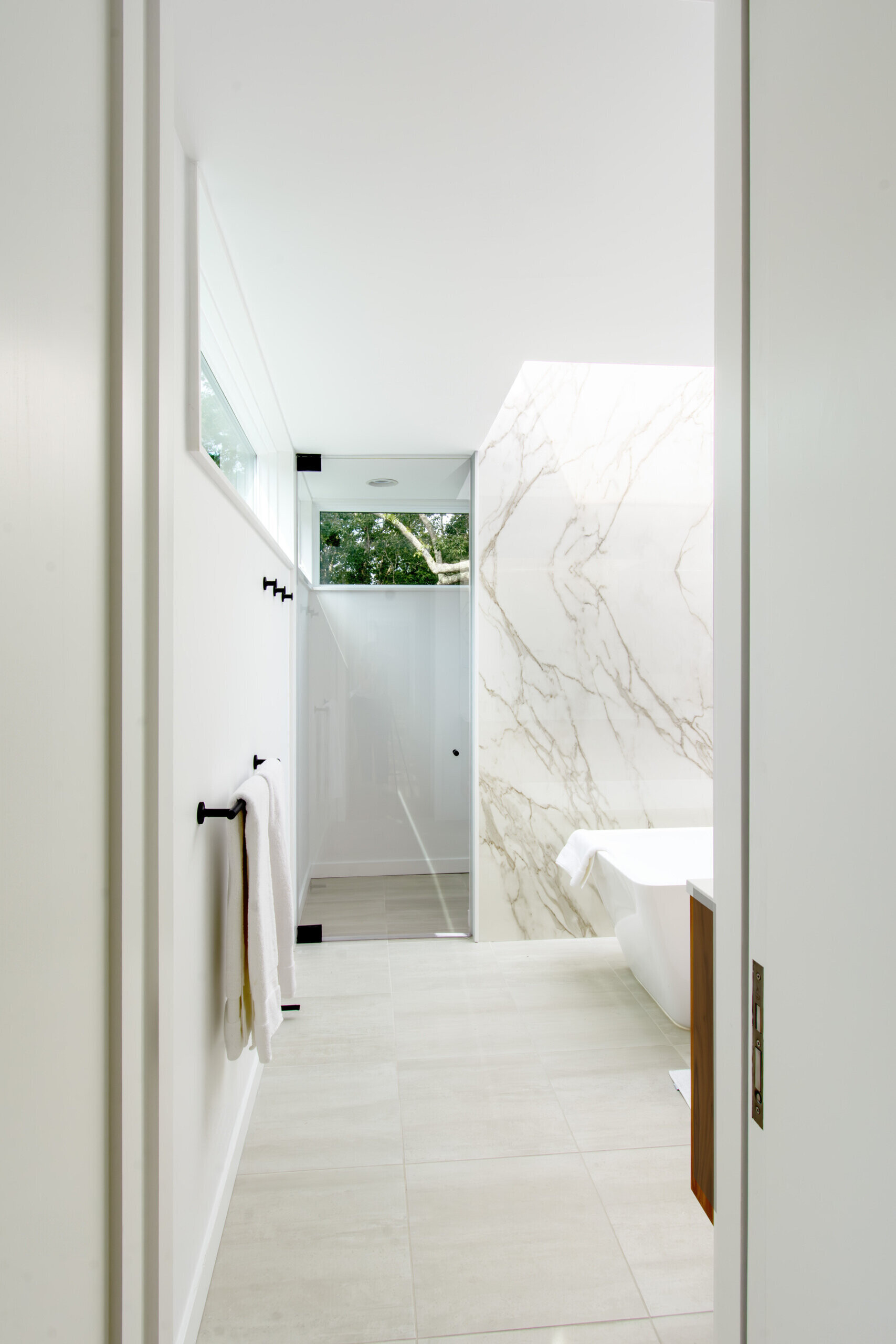 Skylights and warm material finishes give this modern bathroom a bright and relaxing atmosphere.
