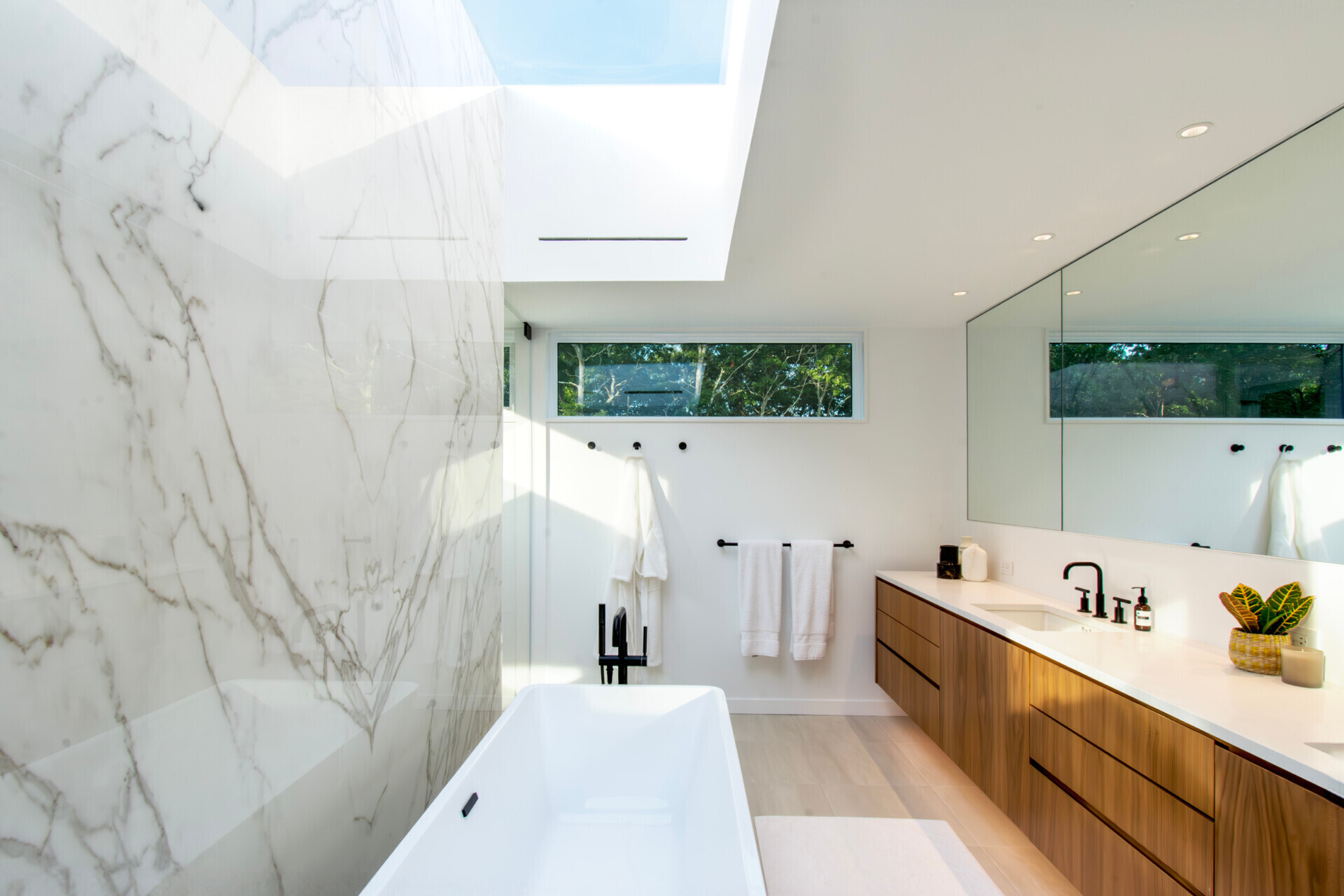 Skylights and warm material finishes give this modern bathroom a bright and relaxing atmosphere.