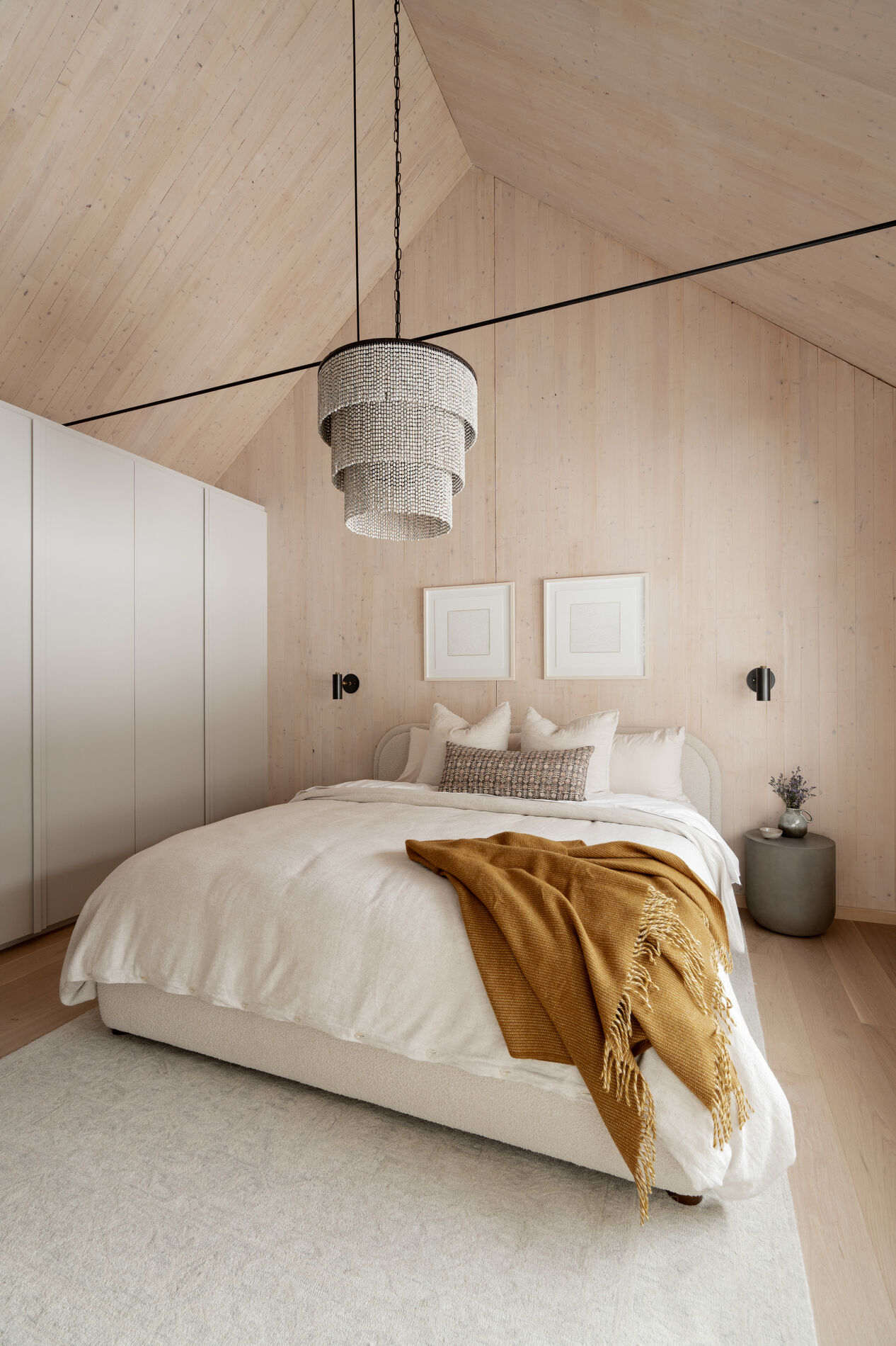 A modern mountain cabin inspired bedroom with wood walls and a built-in desk.