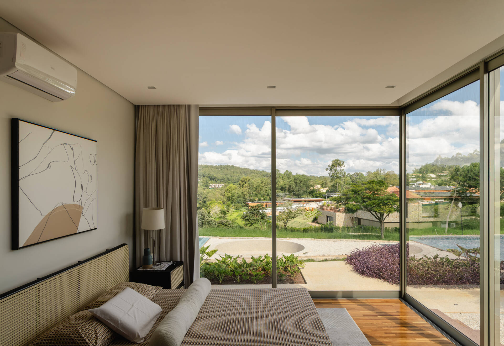 Warm timber finishes and expansive glazing give the bedrooms at Casa Themis peaceful landscape views while maintaining privacy and comfort within the modern layout.