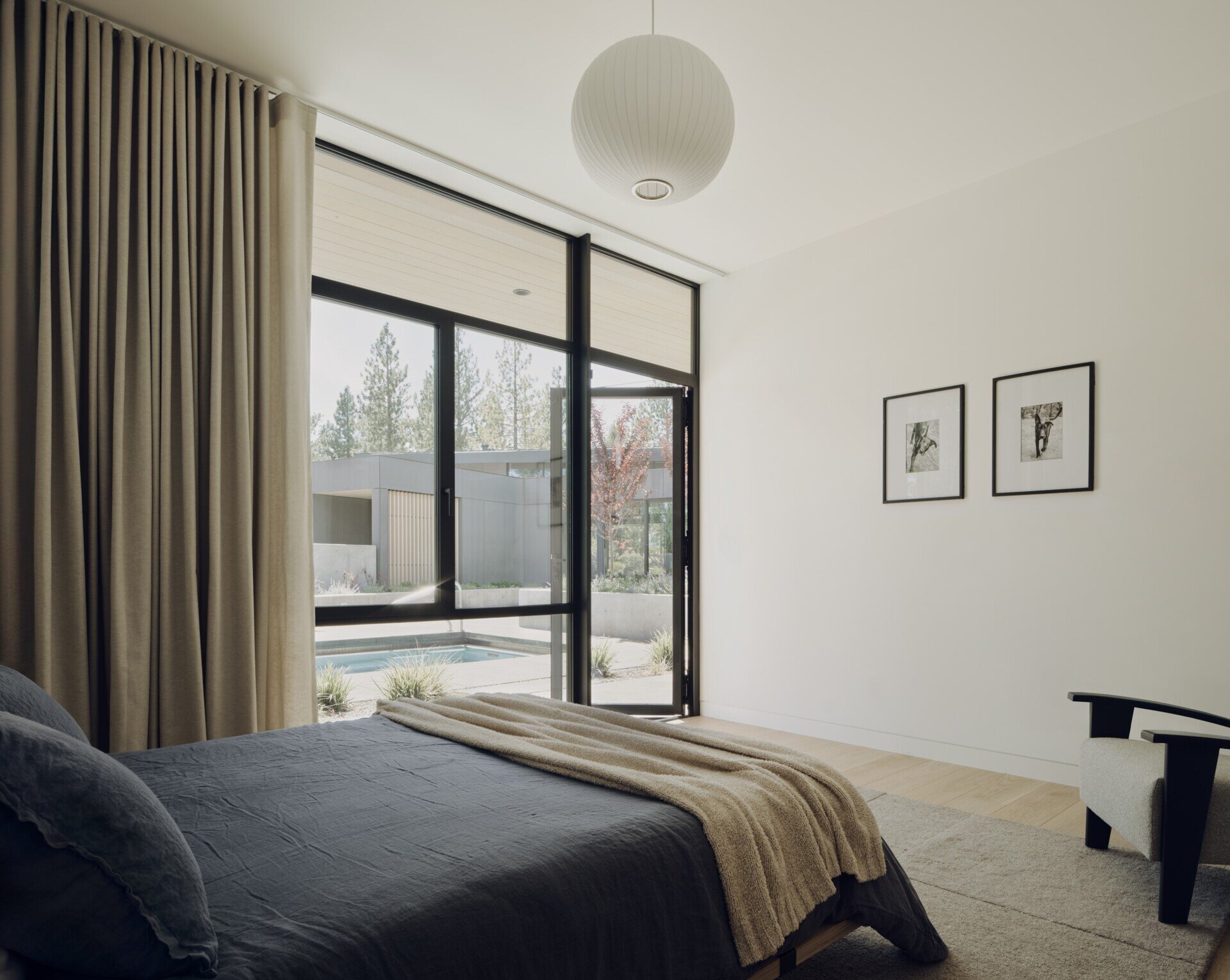 Forest views, private courtyards, and warm minimalist interiors shape the peaceful bedrooms inside this modern Oregon home.
