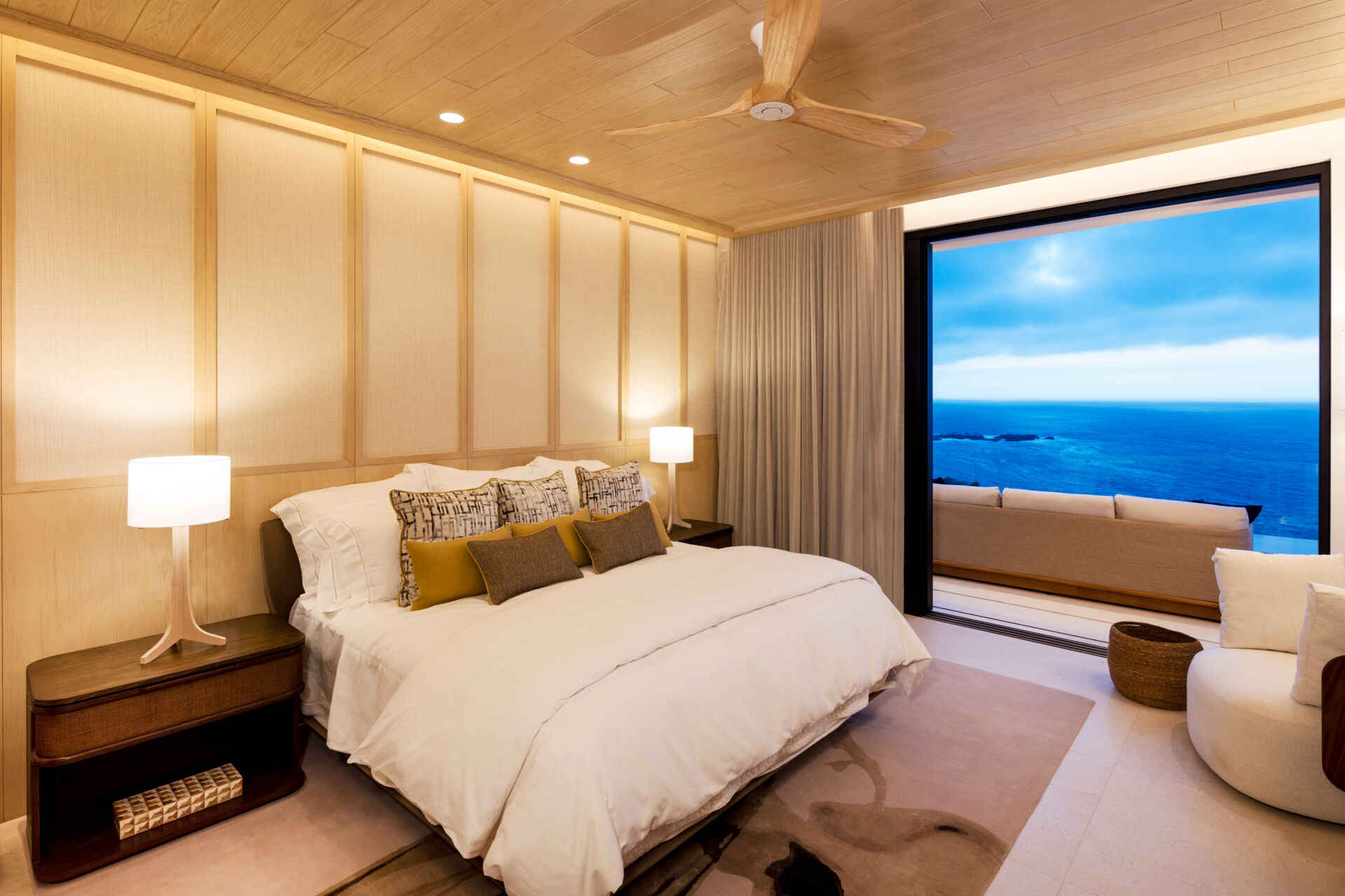 A modern bedroom opens to the outdoors and features natural materials for a calming aesthetic.