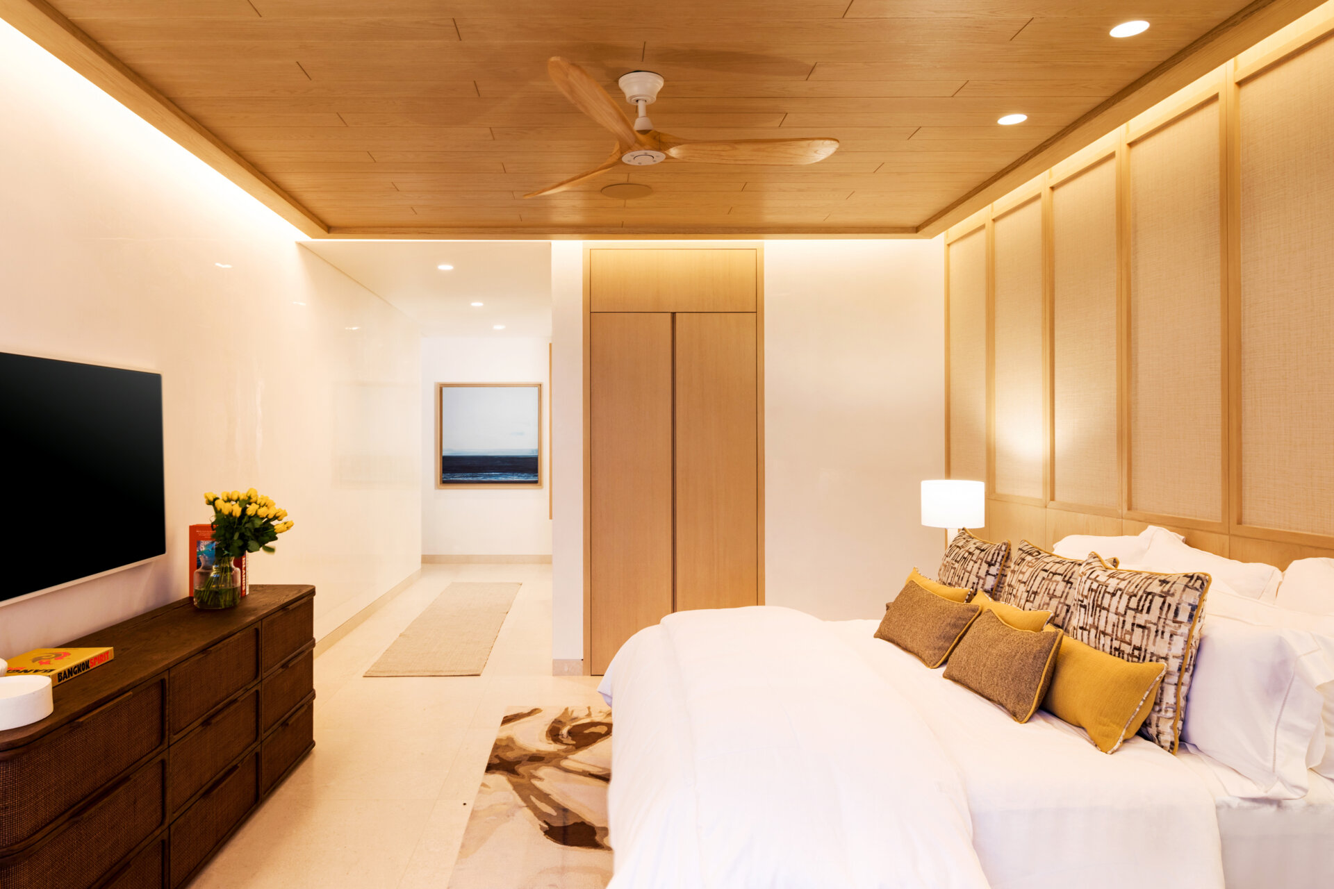 A modern bedroom opens to the outdoors and features natural materials for a calming aesthetic.