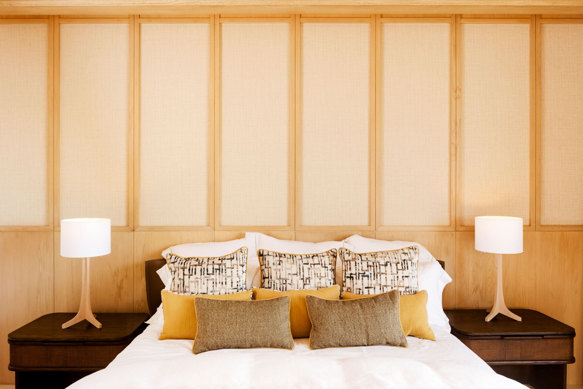 A modern bedroom opens to the outdoors and features natural materials for a calming aesthetic.