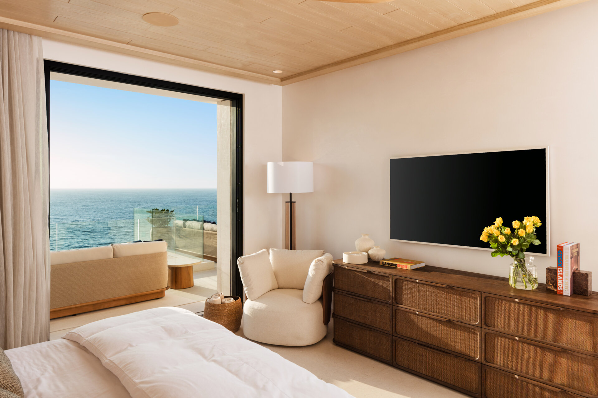 A modern bedroom opens to the outdoors and features natural materials for a calming aesthetic.