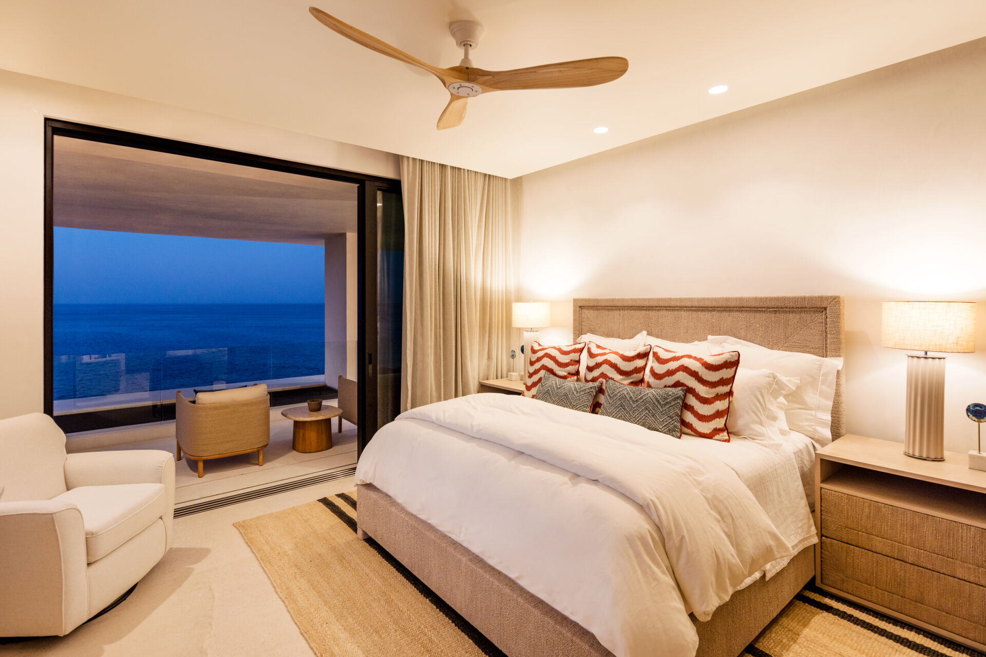 A modern bedroom opens to the outdoors and features natural materials for a calming aesthetic.