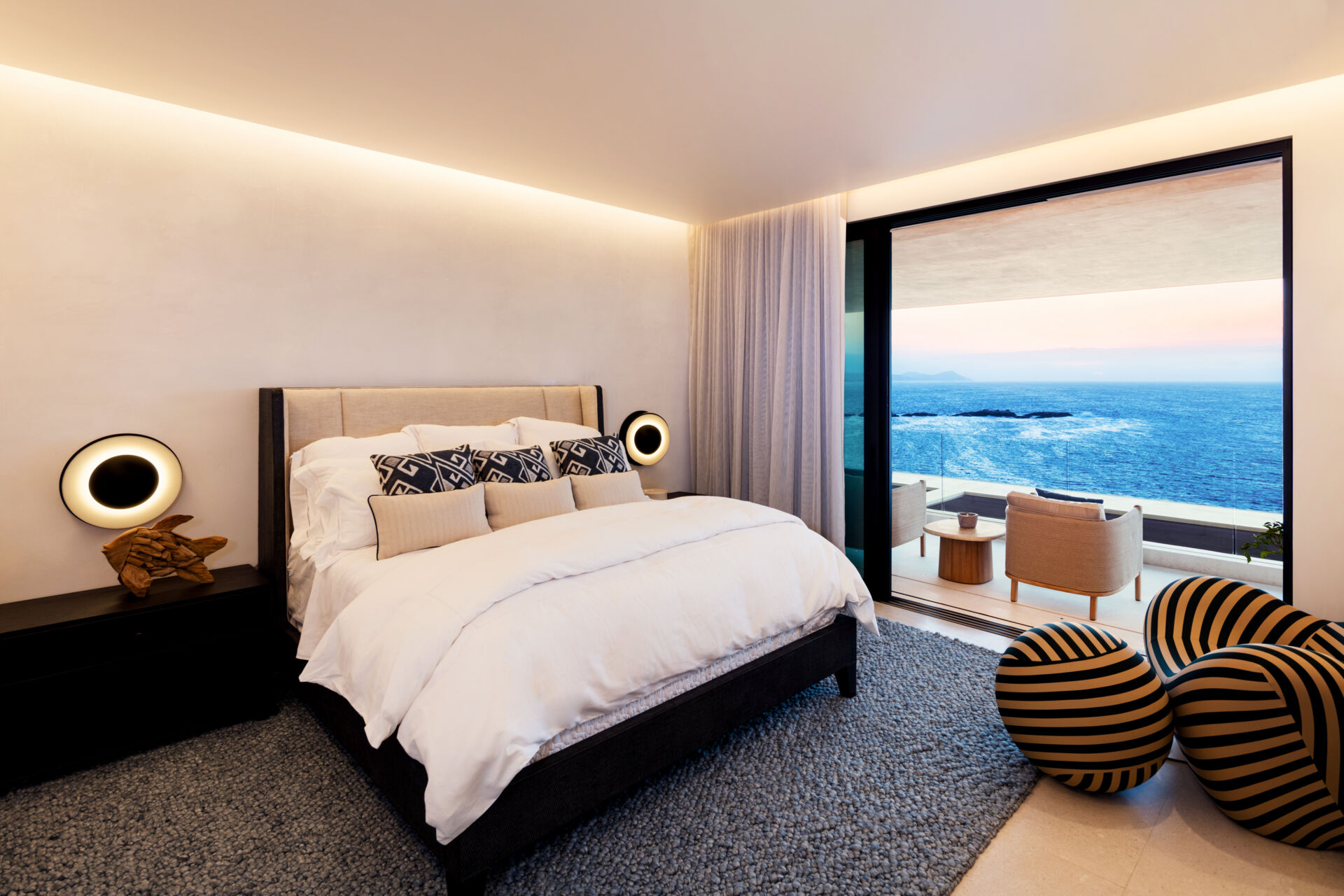 A modern bedroom opens to the outdoors and features natural materials for a calming aesthetic.