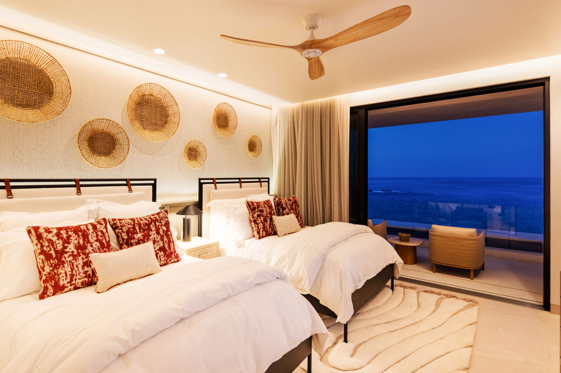 A modern bedroom opens to the outdoors and features natural materials for a calming aesthetic.