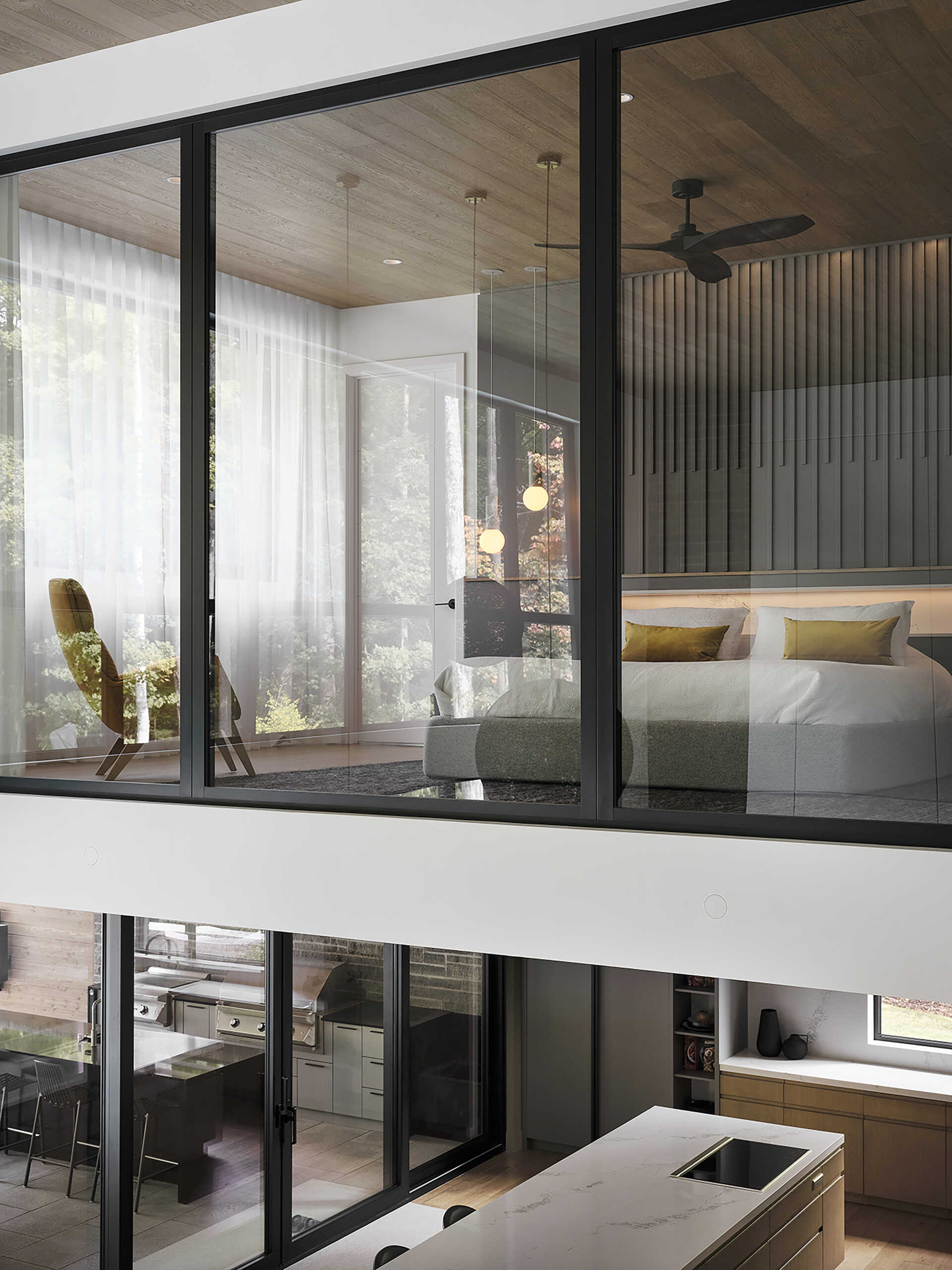 Positioned within the quieter upper areas of the house, the bedroom takes advantage of elevated views toward the surrounding canopy. The space continues the home’s use of warm wood tones and modern finishes, creating an atmosphere that feels soft and uncluttered. 

Natural light shifts throughout the day across the material palette, bringing subtle variation to the room without the need for excessive decoration, while the windows look over the living area below.