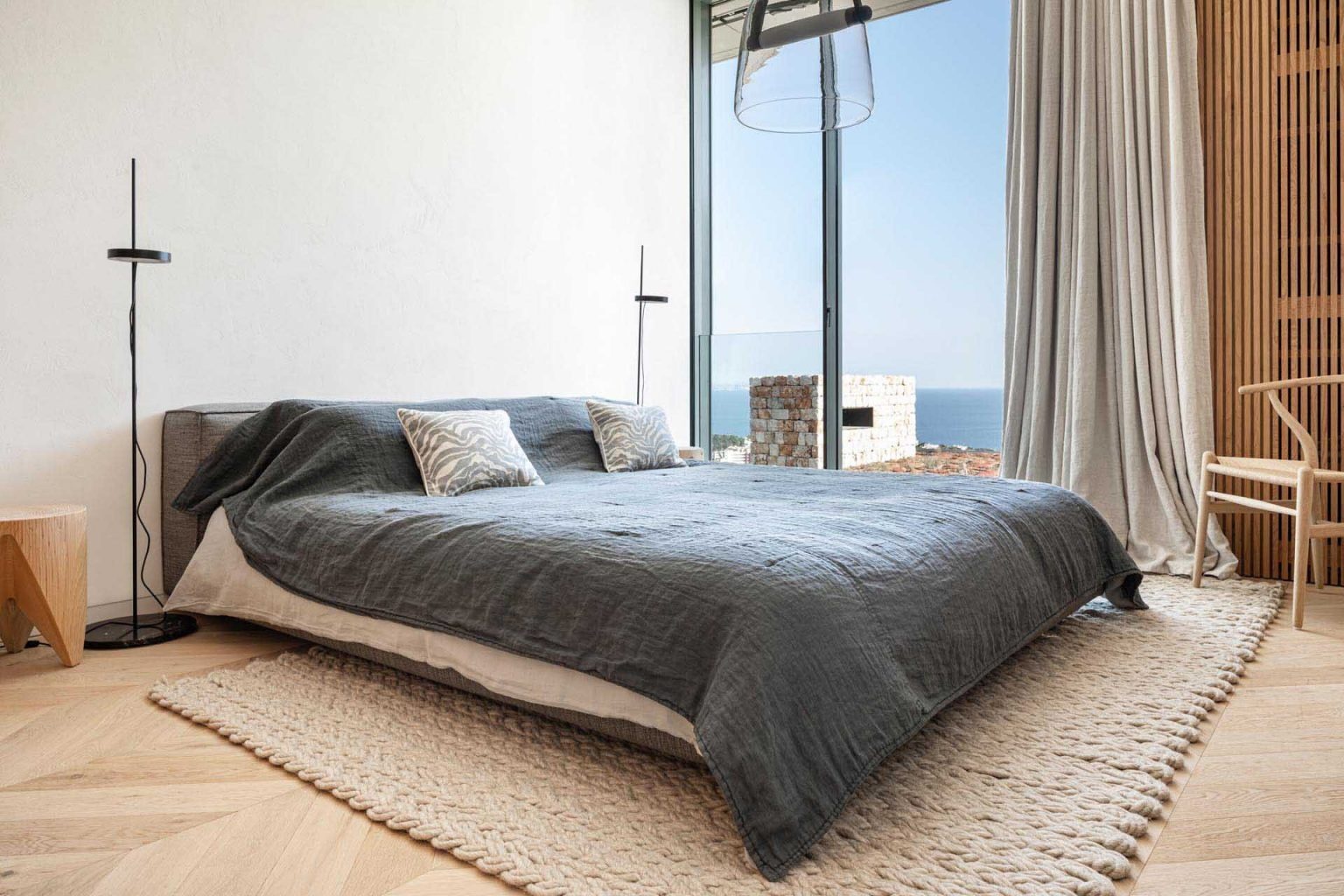 Minimal bedroom with lime plaster, and natural ventilation create bright and airy spaces throughout this Mallorca home.