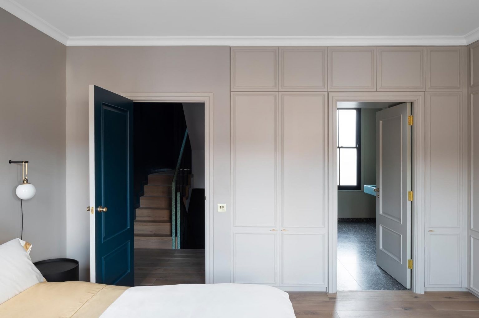 The upper floors of this Victorian London home include a modern main suite with built-in closets, terrazzo details, and minimalist interiors.