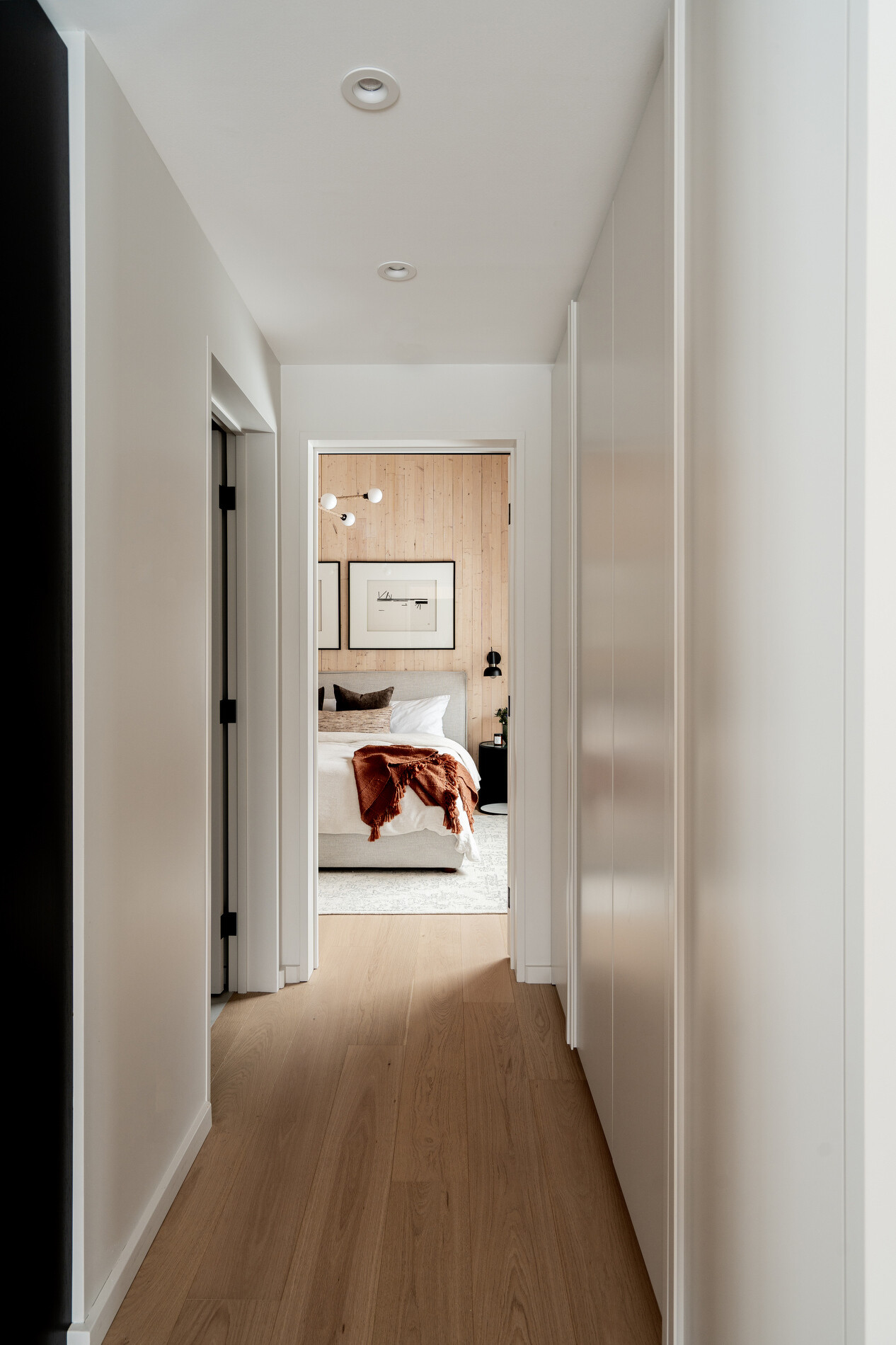 A modern mountain cabin inspired bedroom with wood walls and a built-in desk.