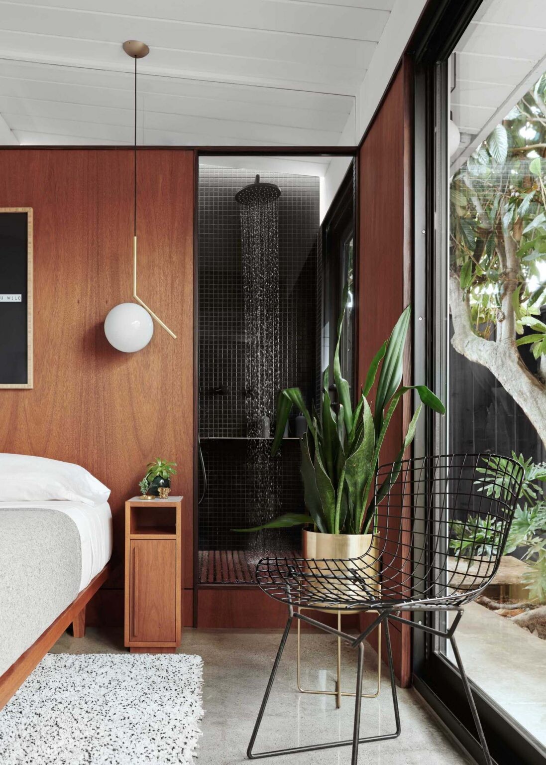 Bali-inspired ensuite design in a San Jose Eichler home, blending indoor bathroom spaces with a private outdoor bathtub and tropical-style planting.
