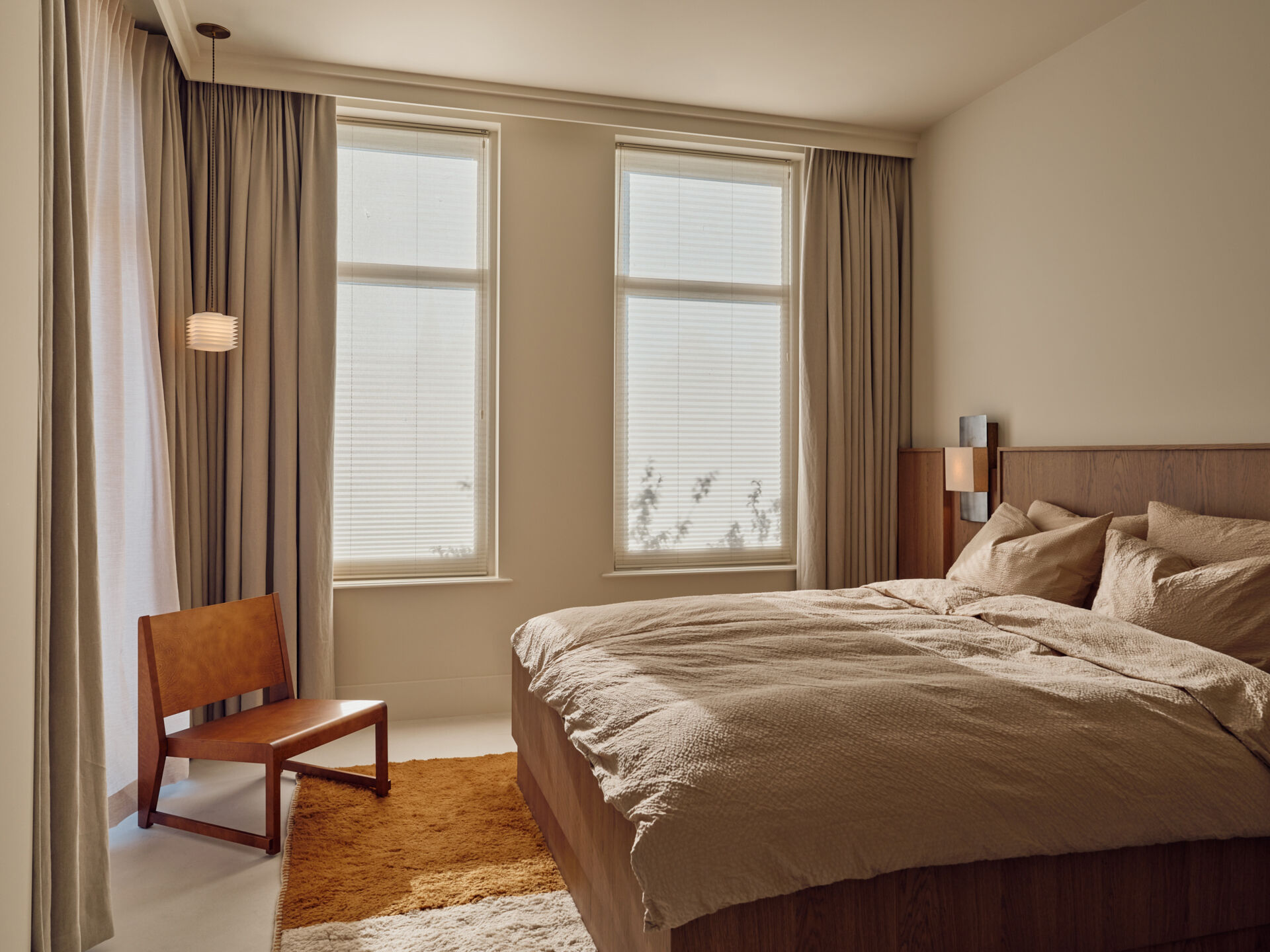 Soft textures, custom bedheads, hidden wardrobes, and warm wood finishes define this calming modern bedroom.