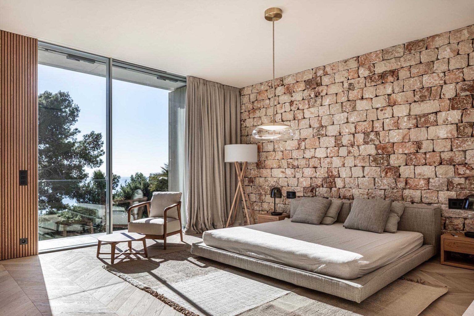 Minimal bedrooms with stone walls, lime plaster, and natural ventilation create bright and airy spaces throughout this Mallorca home.