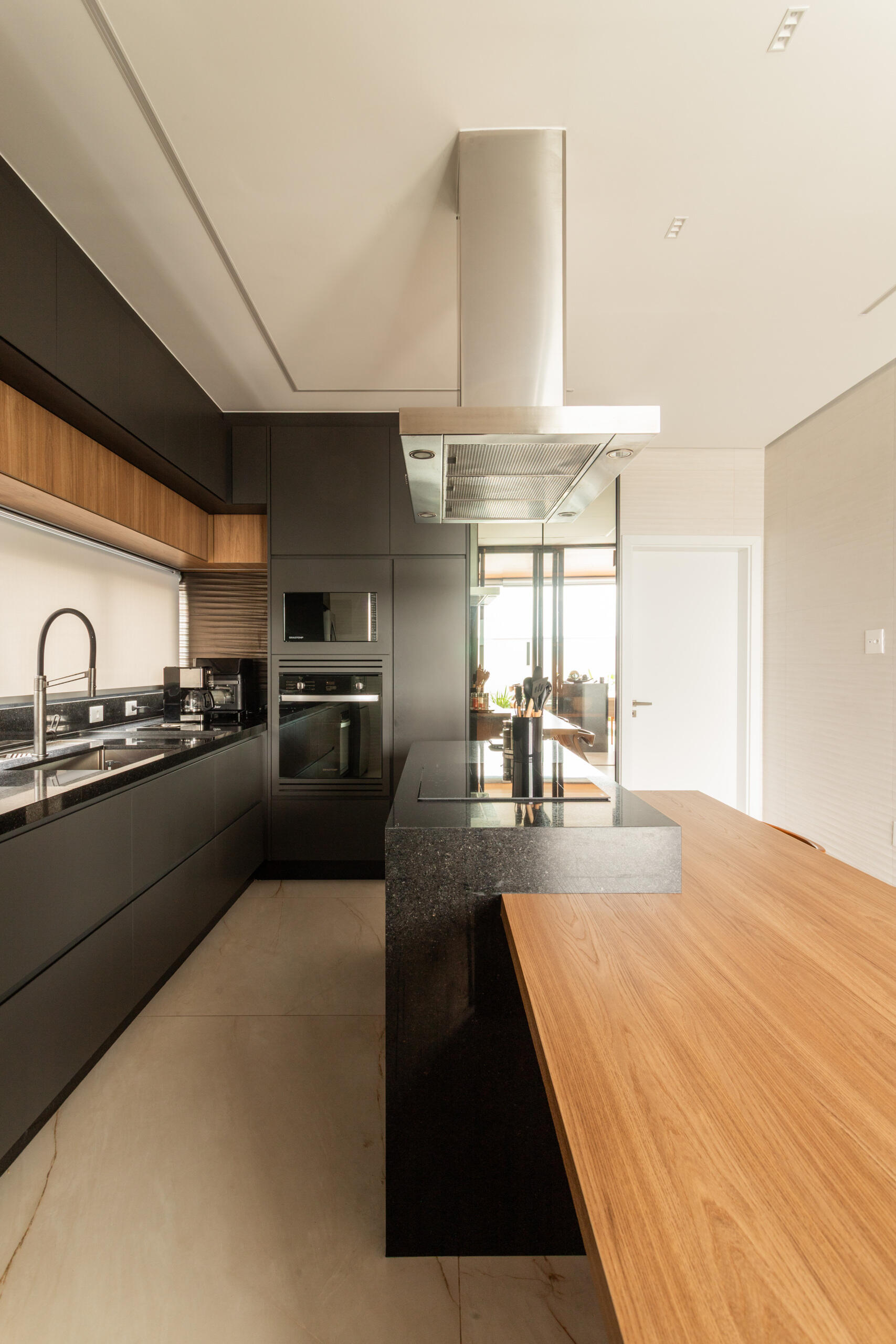 Casa R|L’s kitchen combines sleek contemporary finishes with warm textures and functional open-plan design inside this sculptural Brazilian residence.