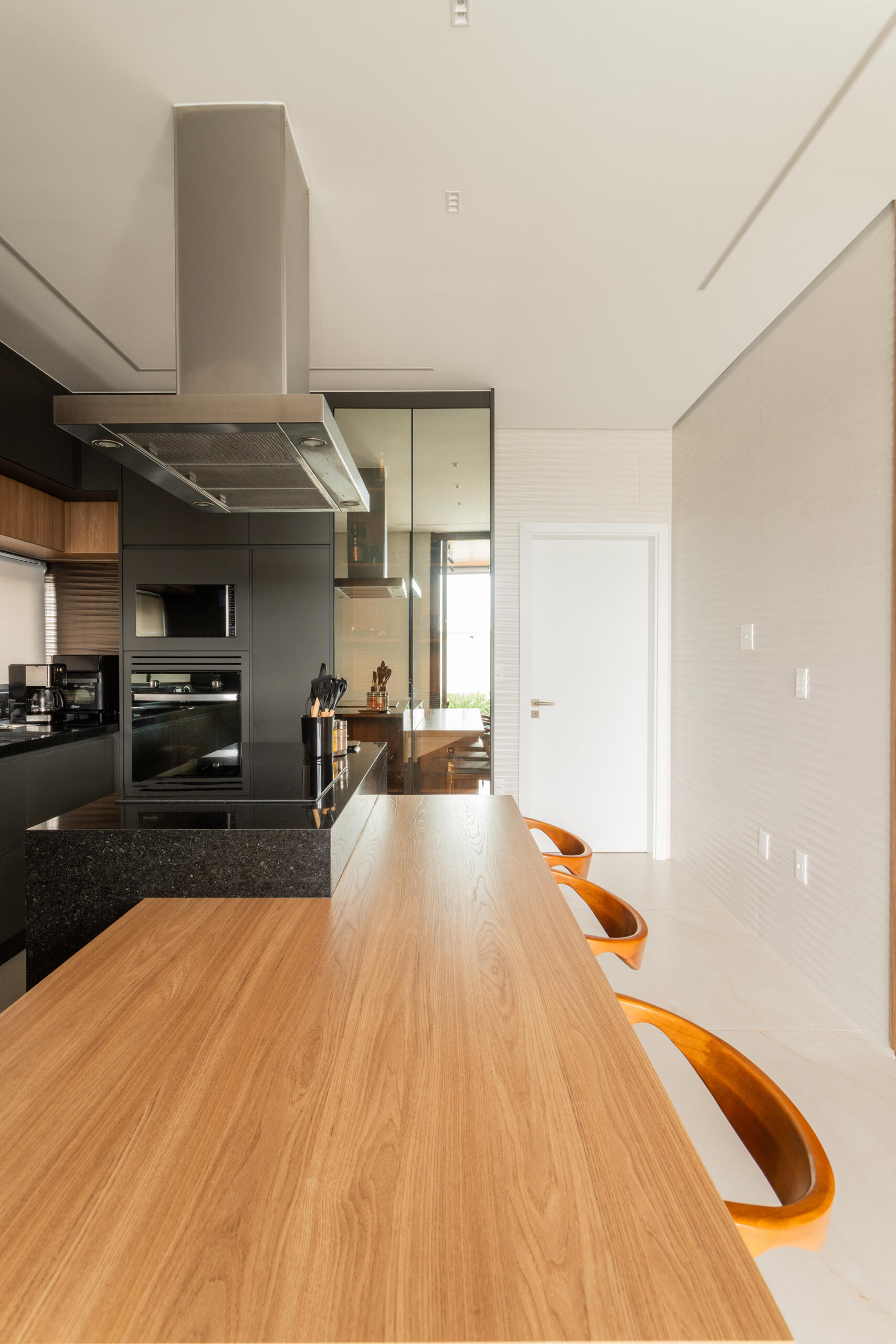 Casa R|L’s kitchen combines sleek contemporary finishes with warm textures and functional open-plan design inside this sculptural Brazilian residence.