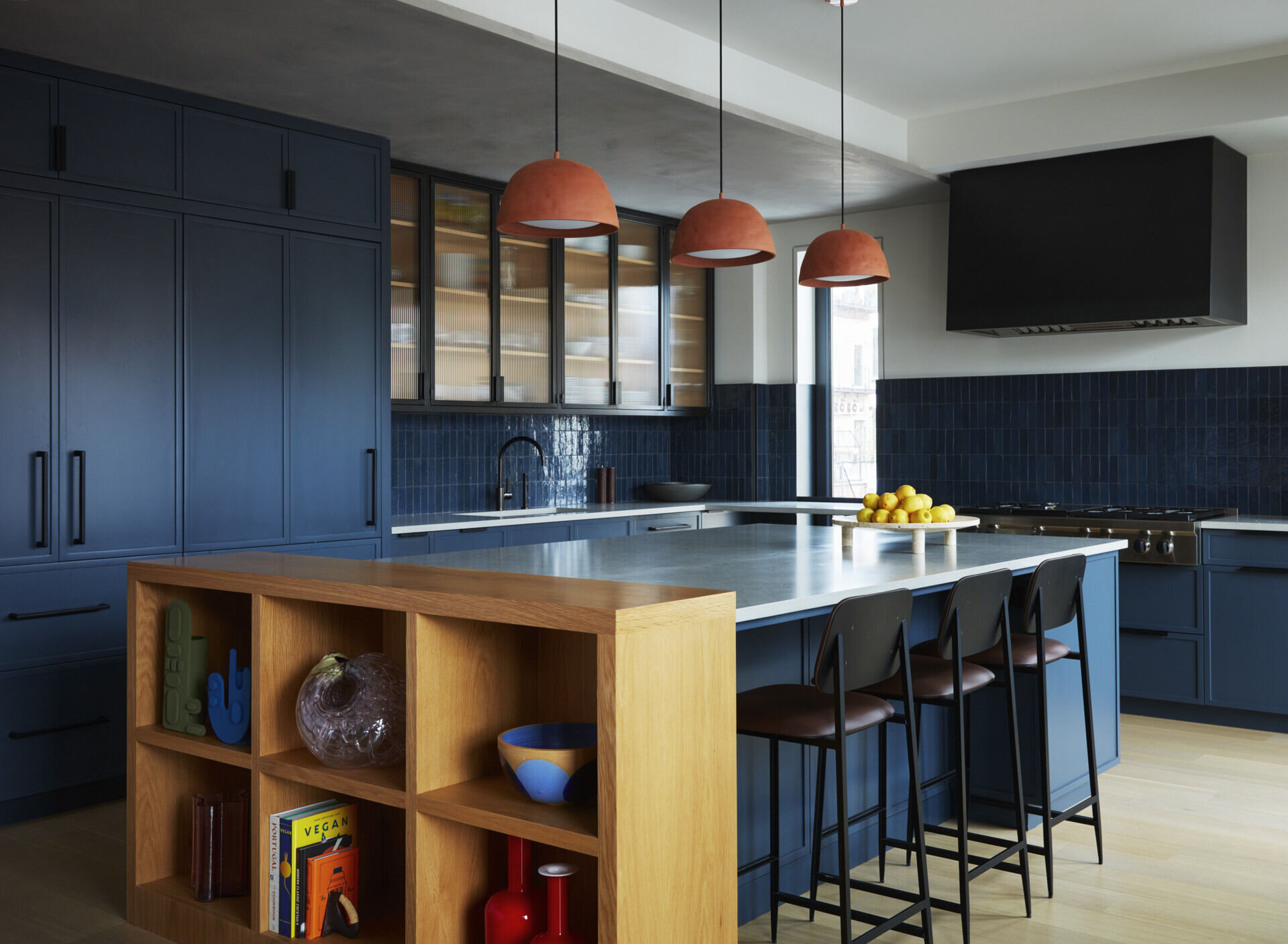 This navy kitchen pairs White Oak, blackened steel, quartz countertops, and Zellige tiles for a bold modern look.