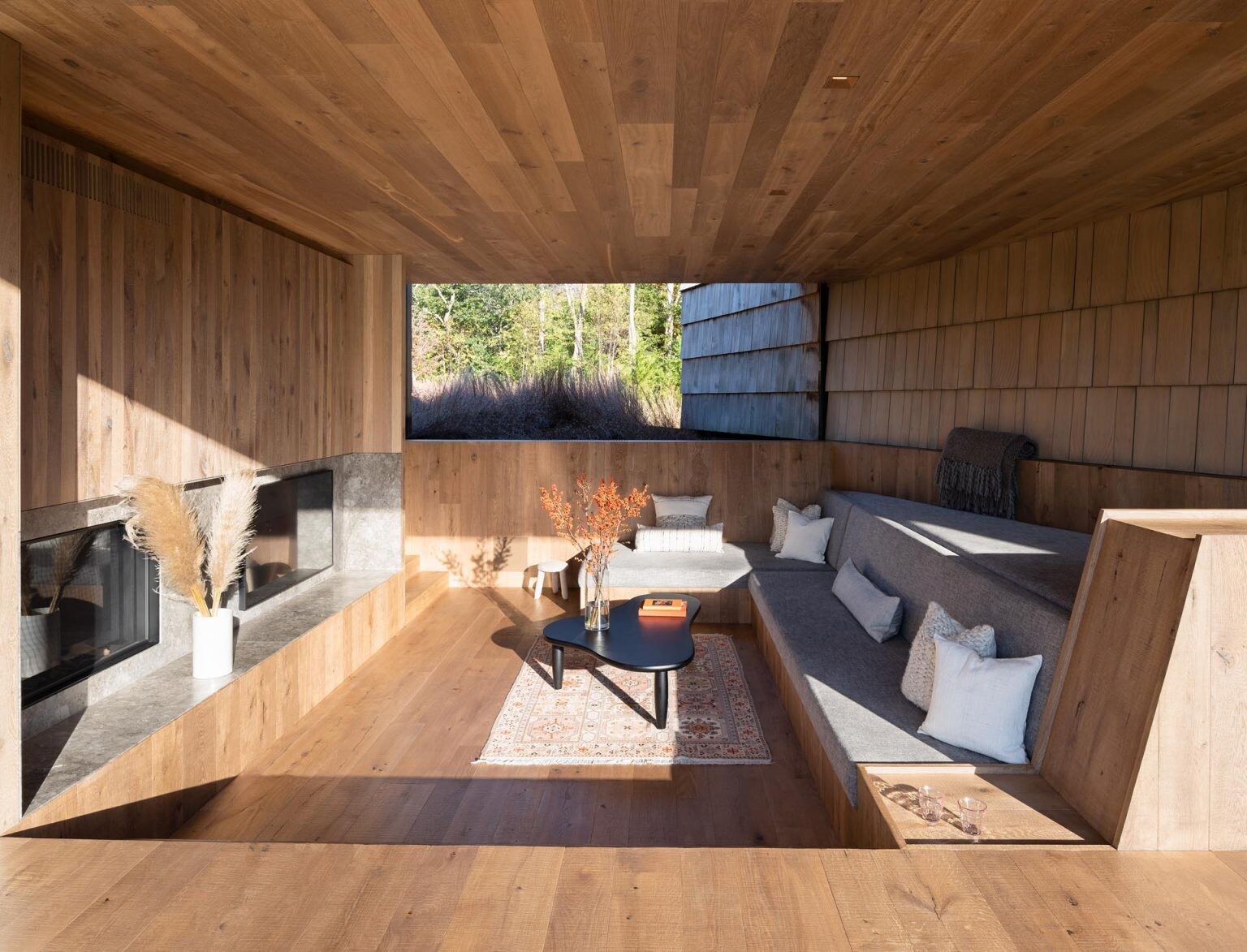 Oversized fireplaces, covered lounges, and a built-in poolside daybed turn this modern home into the perfect space for relaxed outdoor living.