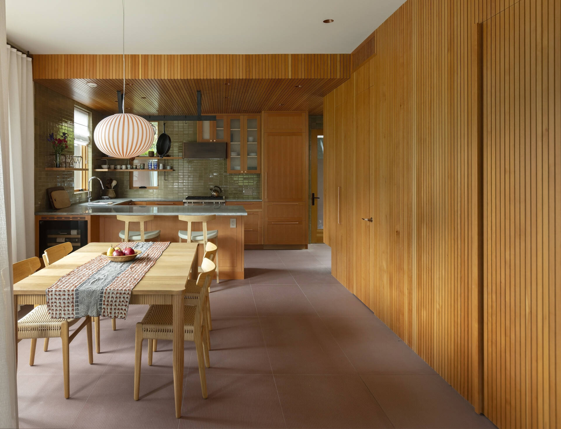 This Whistler kitchen features hidden doors, warm Douglas fir millwork, and a custom dining table with beautiful handcrafted detailing.