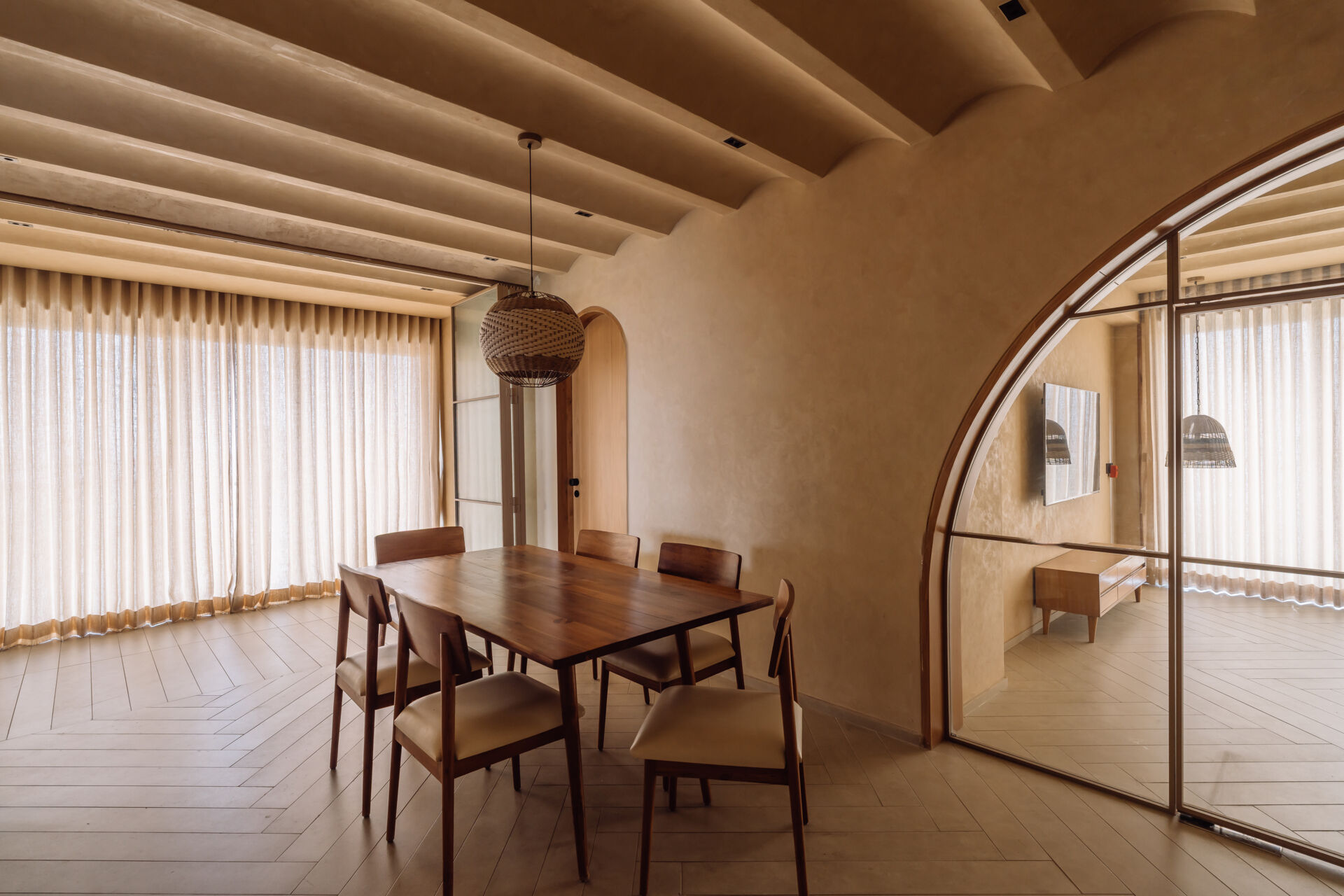 An open plan dining room features arches that lead to other rooms, like the living room.