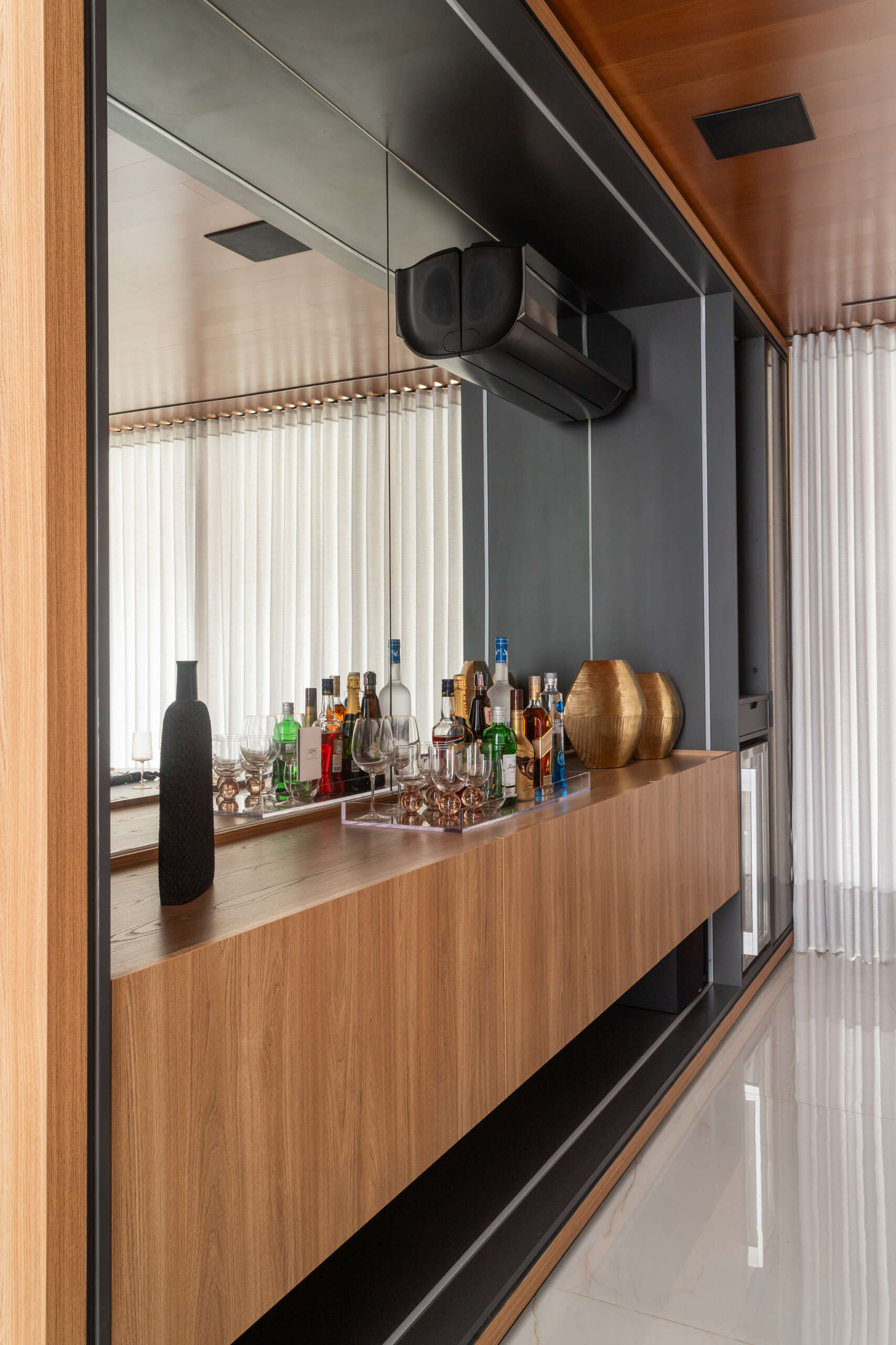 This modern dining room in Casa R|L features open-plan living, warm finishes, and seamless flow between interior spaces in a contemporary home in Brazil.