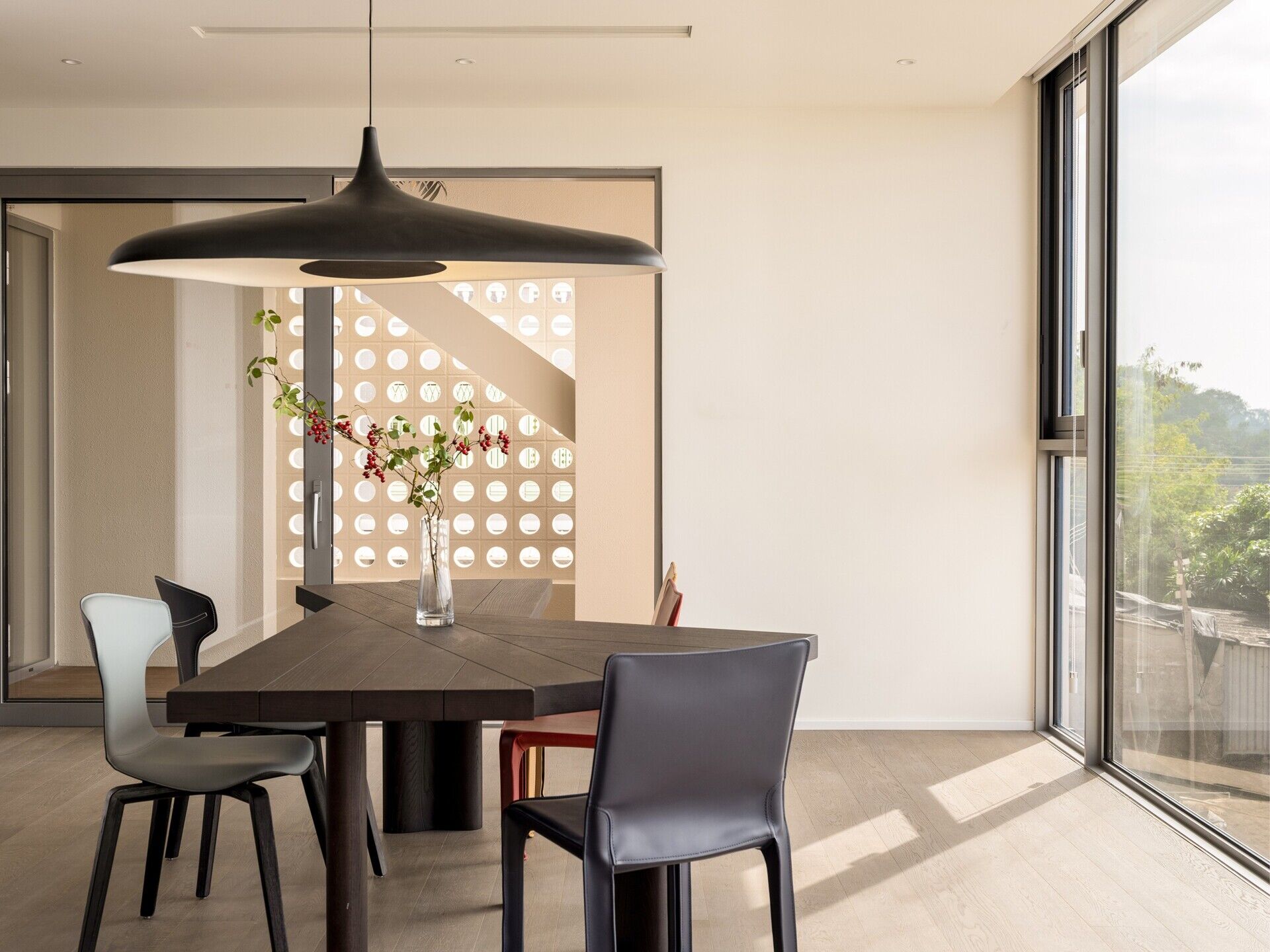 A modern dining room with angular wood table.