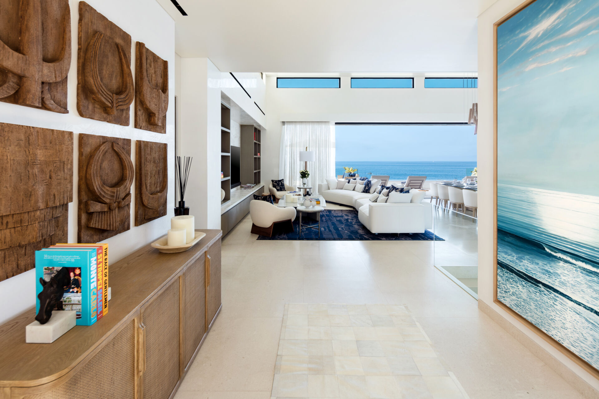 The living room in this Los Cabos condo combines ocean views, layered woods, and relaxed seating designed for family gatherings.