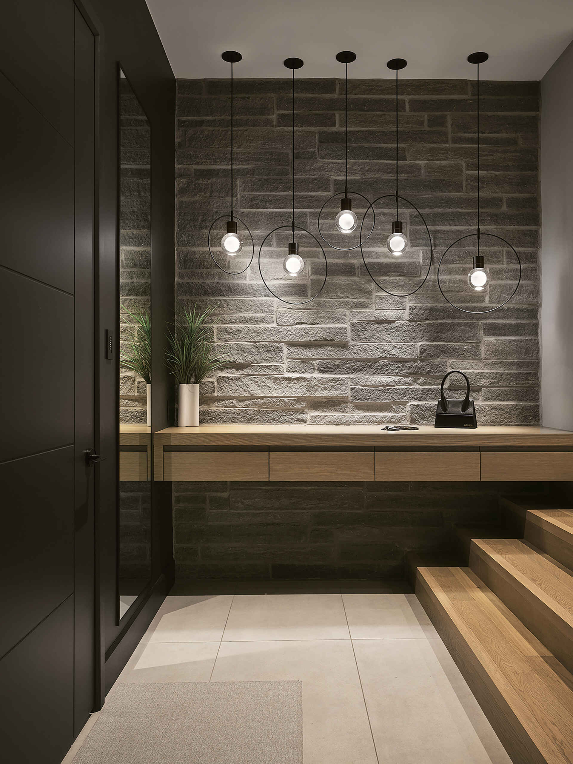This modern entryway combines natural stone, warm wood ceilings, and clean architectural lines to create a welcoming first impression inside a luxury Canadian home.