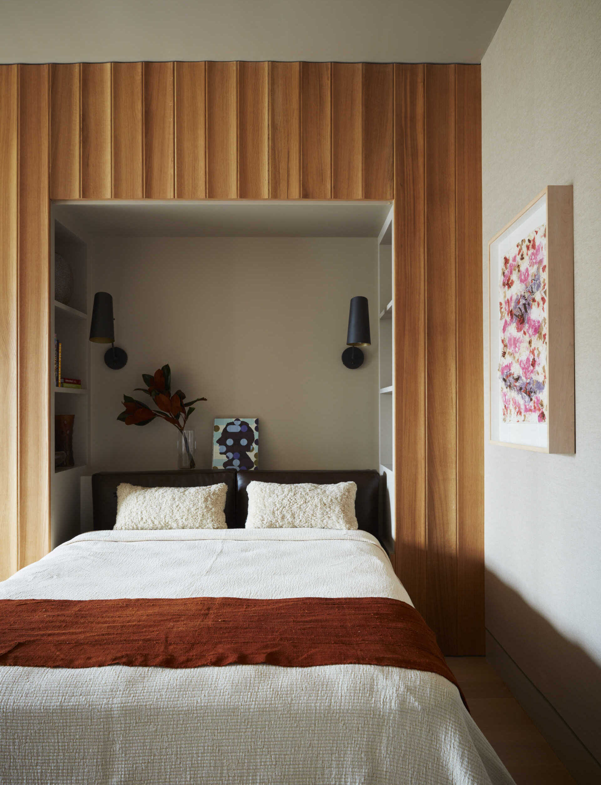 A hidden wall bed, White Oak paneling, and grasscloth wallpaper give this guest bedroom a clever modern design.