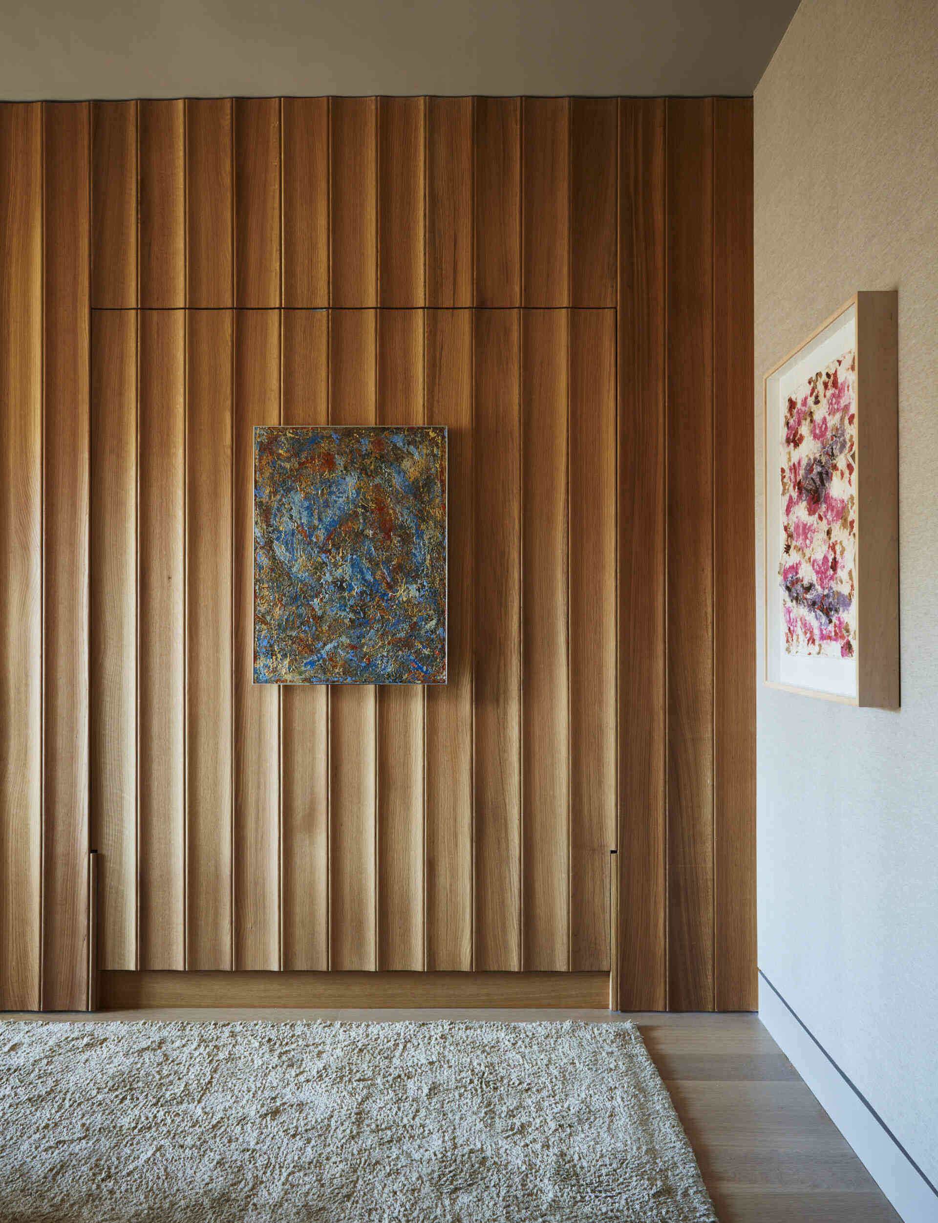A hidden wall bed, White Oak paneling, and grasscloth wallpaper give this guest bedroom a clever modern design.