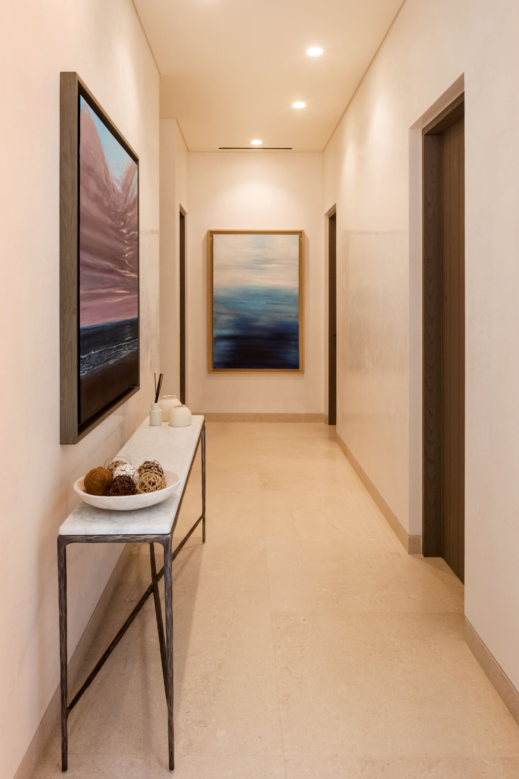 The circulation spaces throughout the condo continue the home’s material palette while creating quieter visual pauses between rooms, with artwork providing a colorful element.