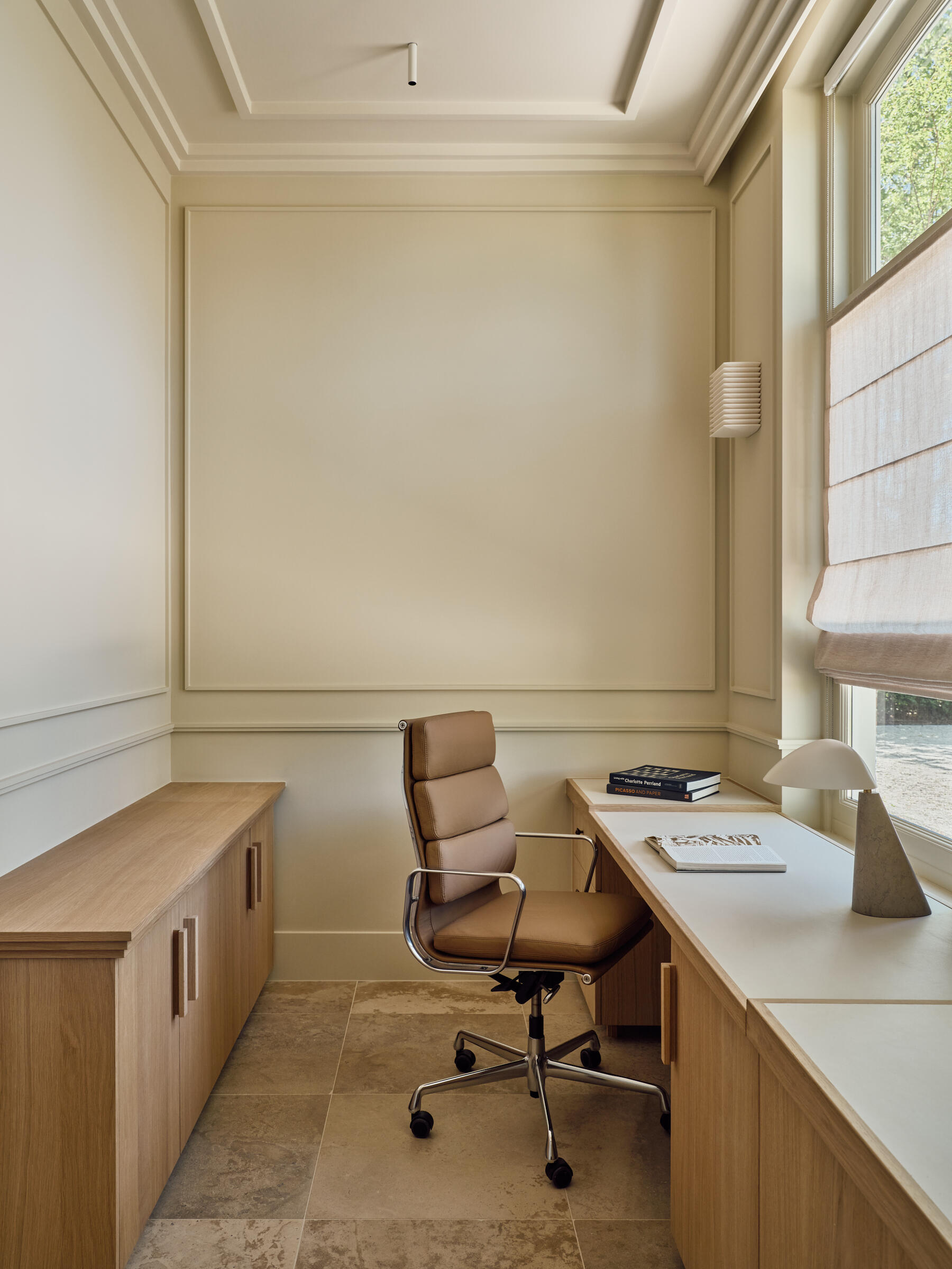 This bright home office combines garden views, built-in furniture, and all-day natural light to create a relaxing space for working.