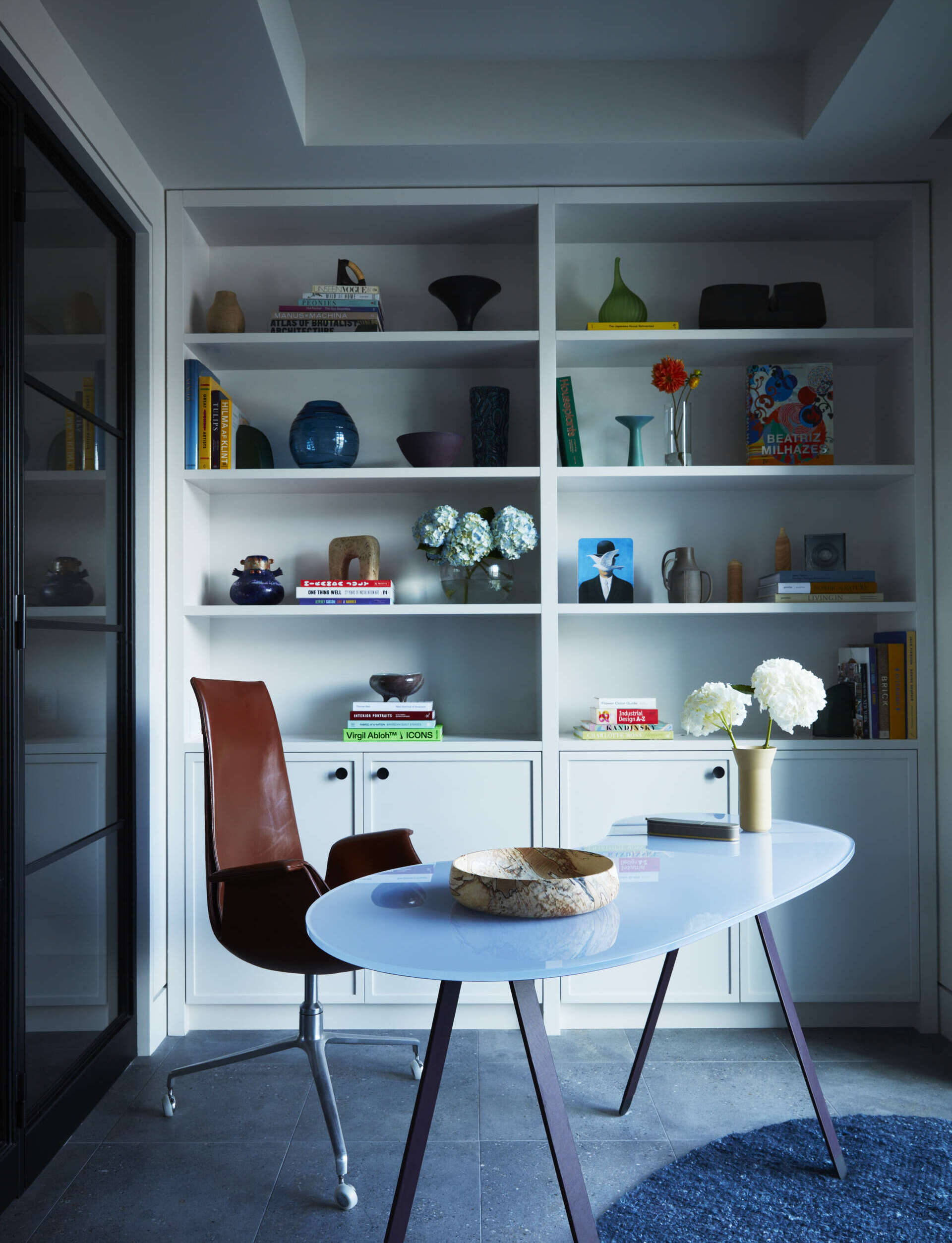 This flexible home office features vintage furniture and soft neutral tones for a refined workspace.