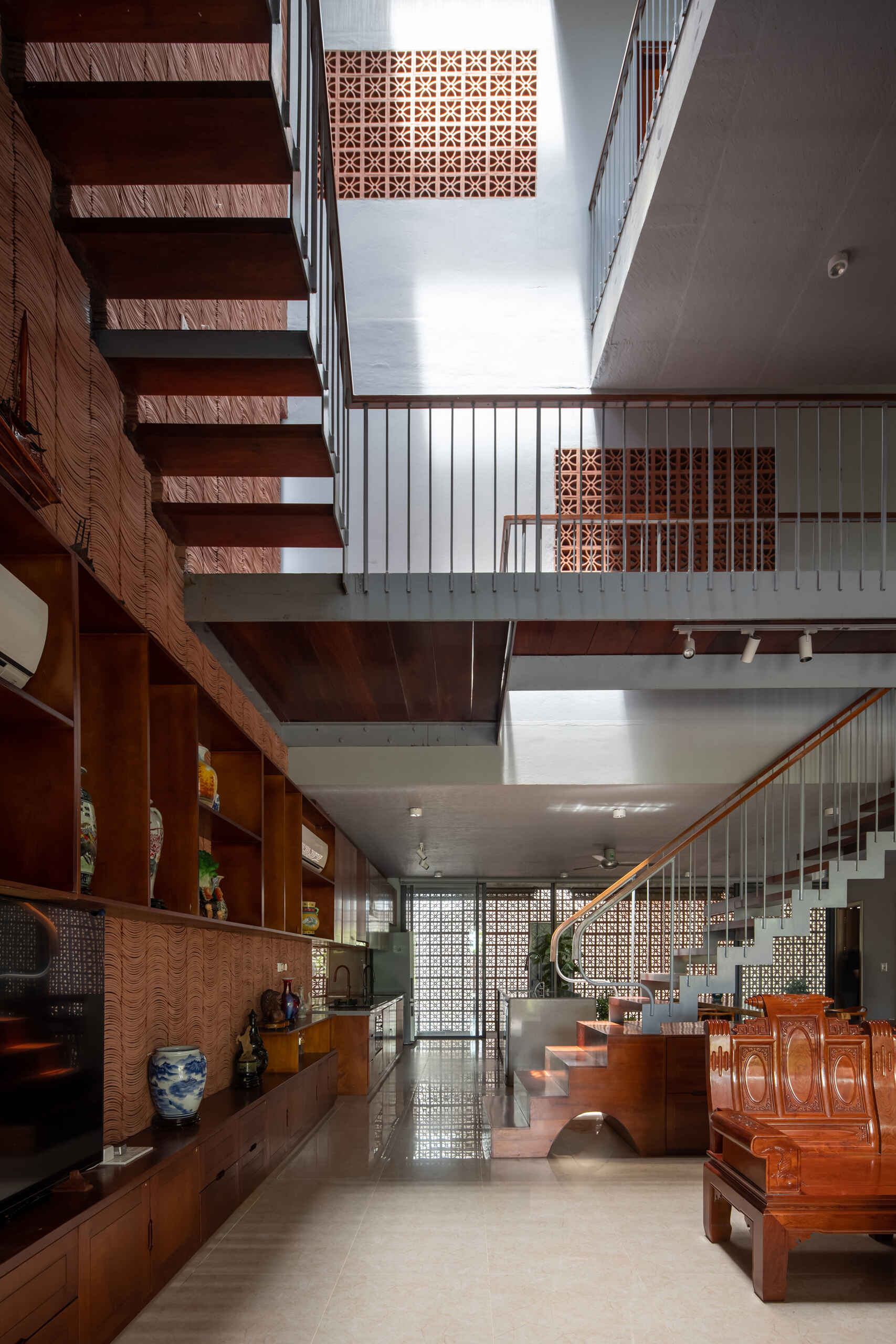The staircase offers changing views of greenery and light as it connects each level.