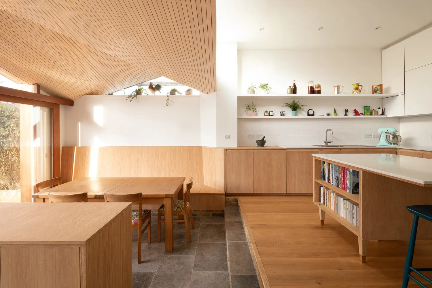 An angled timber ceiling brings warmth, texture, and framed sky views into this contemporary London home extension.
