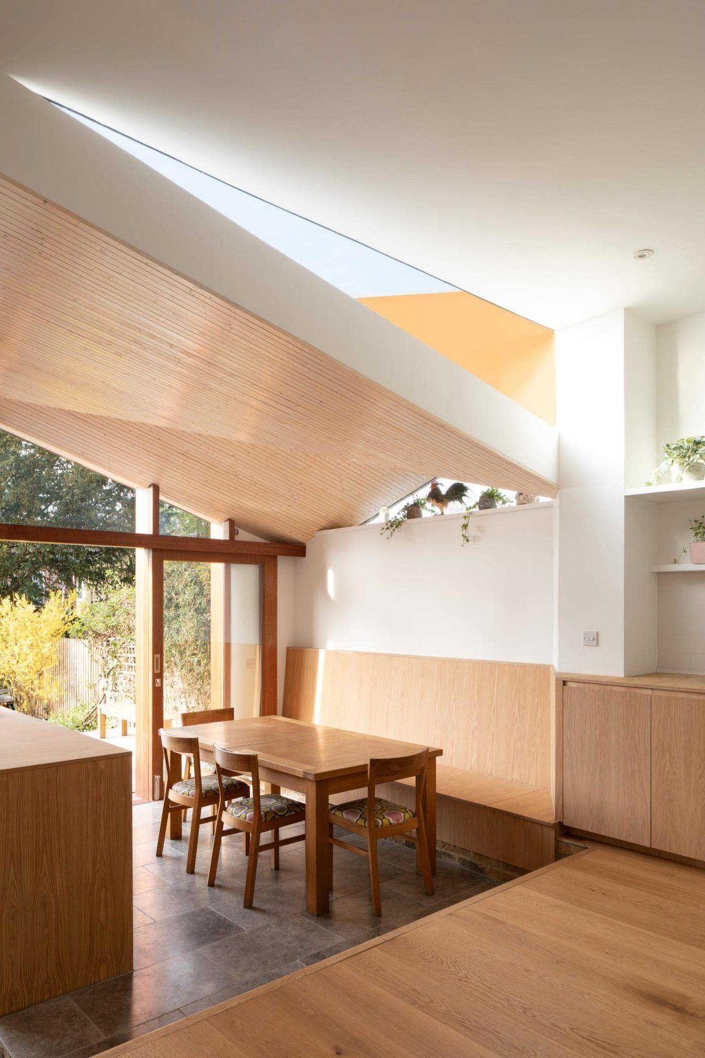Split-level floors and changing materials help define the kitchen, dining room, and snug in this open-plan London extension.