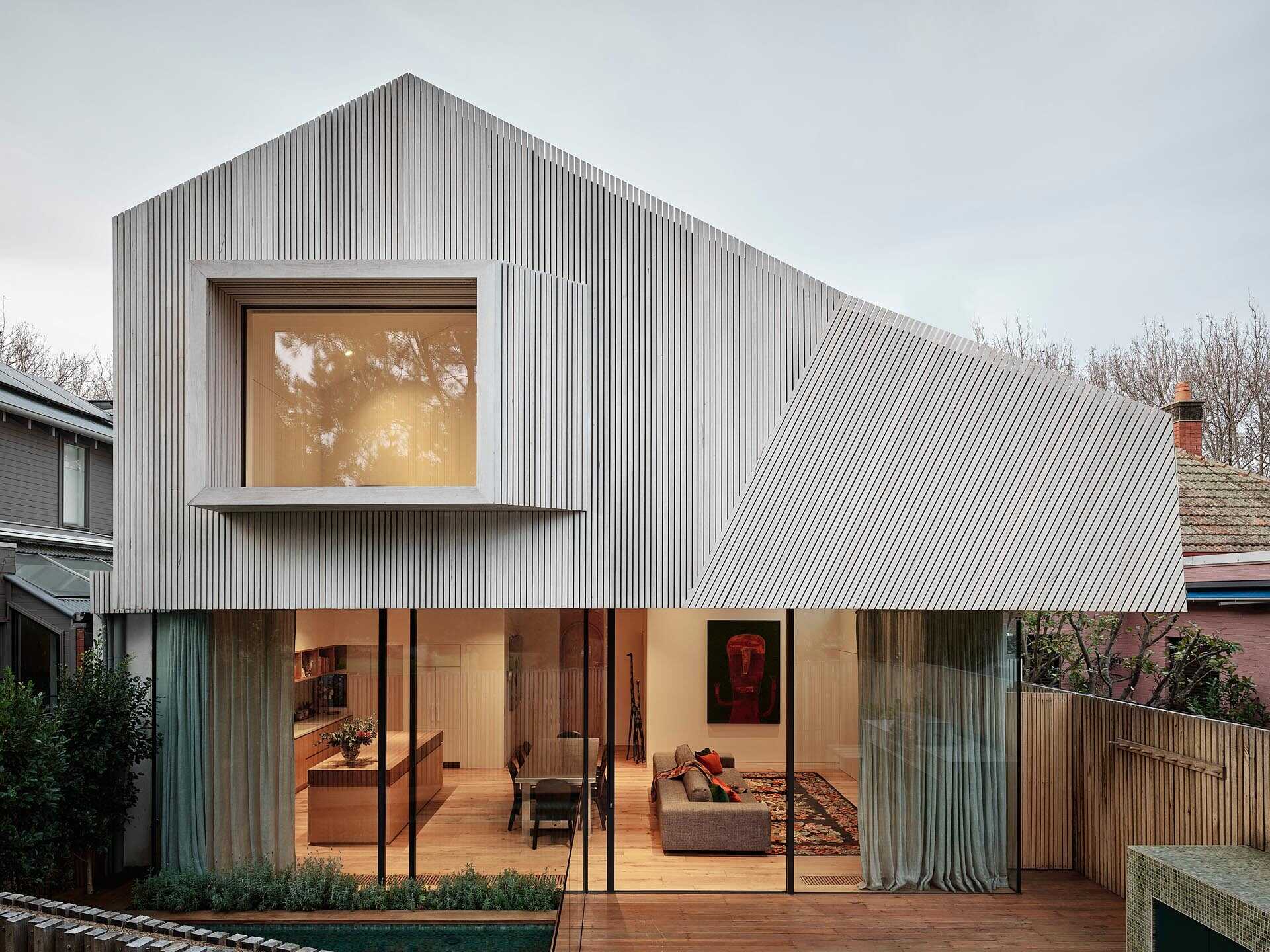 The white blackbutt facade on this Melbourne home creates a fresh coastal-inspired look, while the floating upper level overlooks a green plunge pool and neighboring park.
