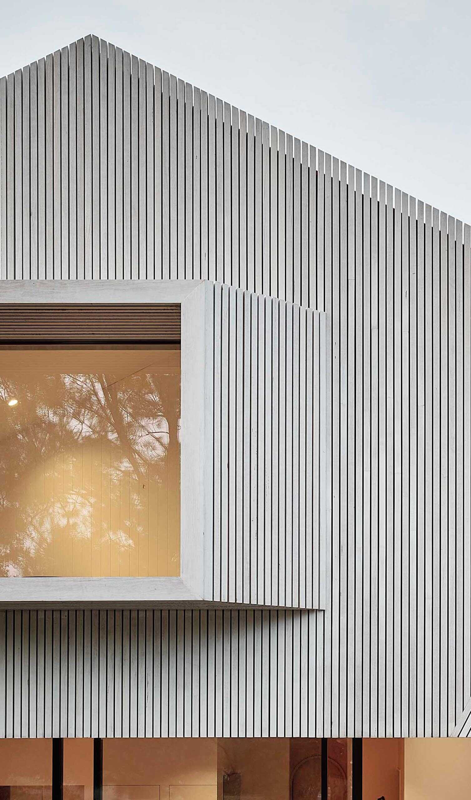 The white blackbutt facade on this Melbourne home creates a fresh coastal-inspired look, while the floating upper level overlooks a green plunge pool and neighboring park.