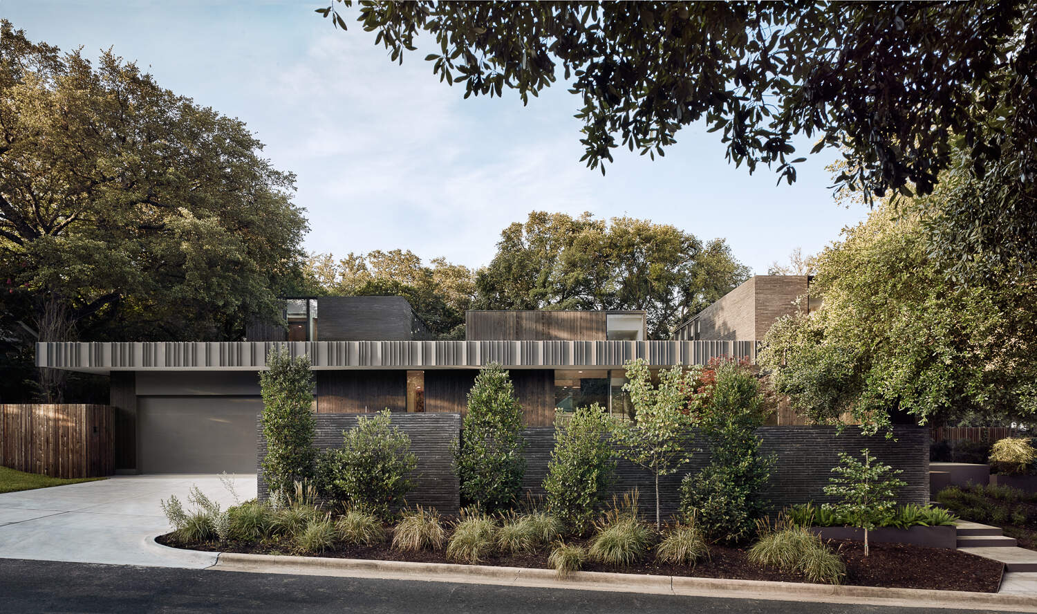 Tour the bold exterior of Tarrytown Residence, where black brick, ebony-stained cedar, custom steel detailing, and expansive glass walls create a contemporary architectural statement in Austin, Texas.