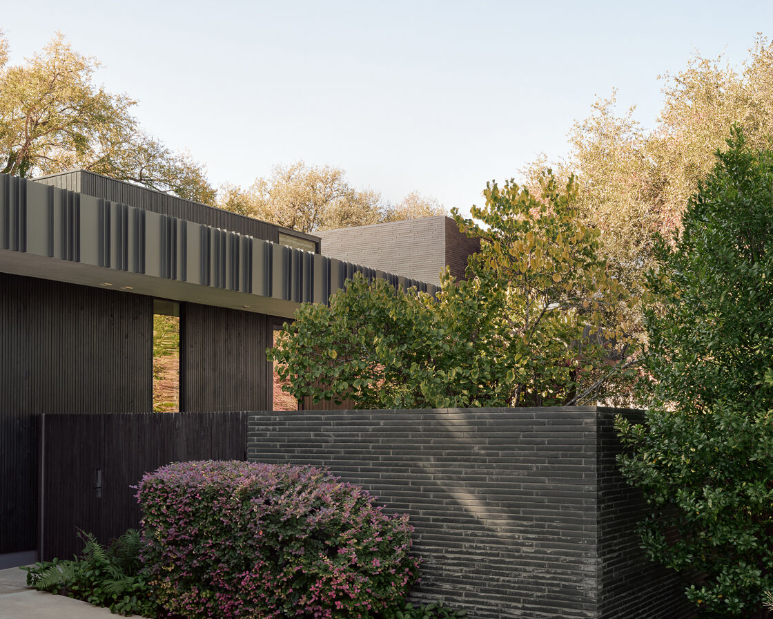 Tour the bold exterior of Tarrytown Residence, where black brick, ebony-stained cedar, custom steel detailing, and expansive glass walls create a contemporary architectural statement in Austin, Texas.