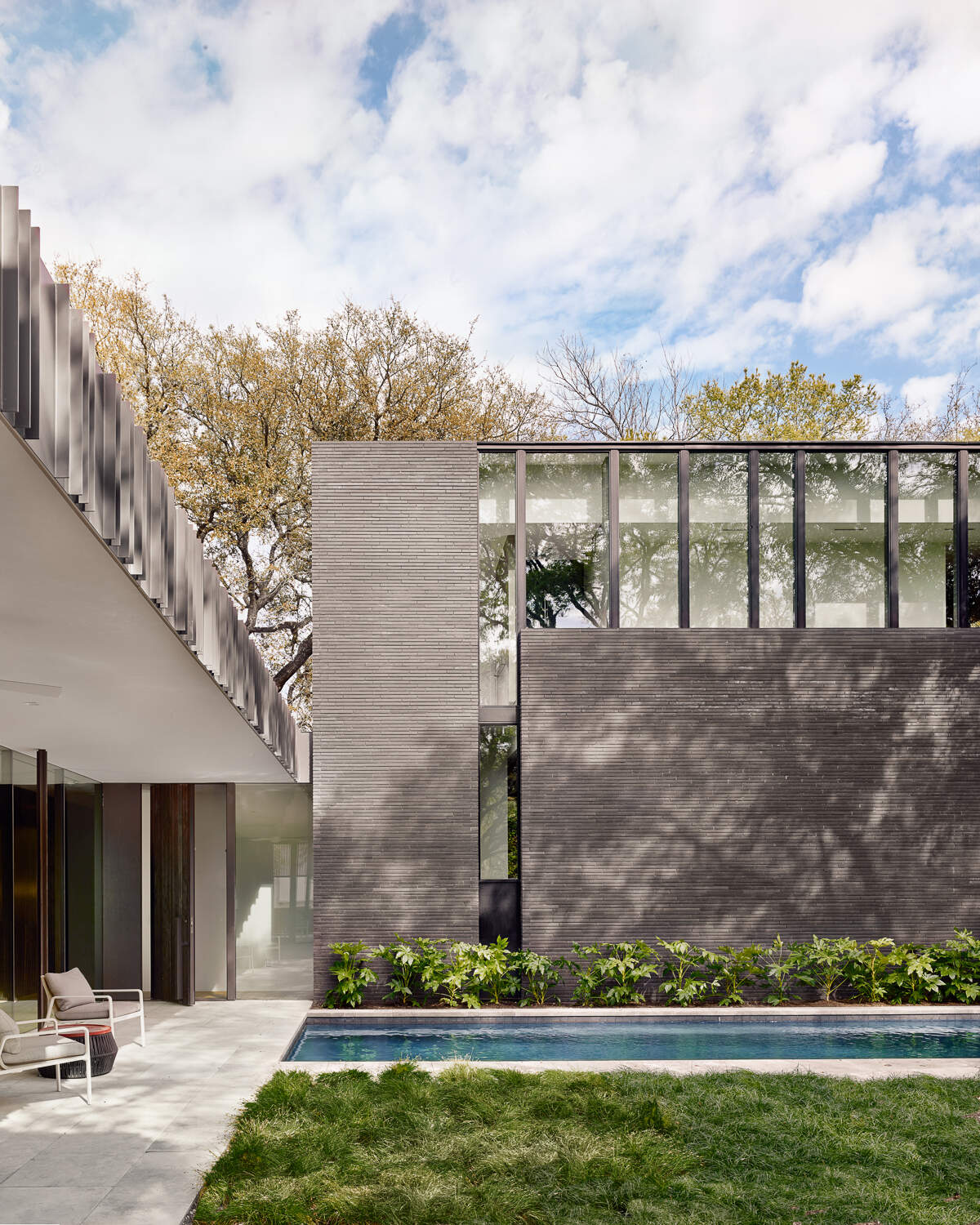 Tour the bold exterior of Tarrytown Residence, where black brick, ebony-stained cedar, custom steel detailing, and expansive glass walls create a contemporary architectural statement in Austin, Texas.