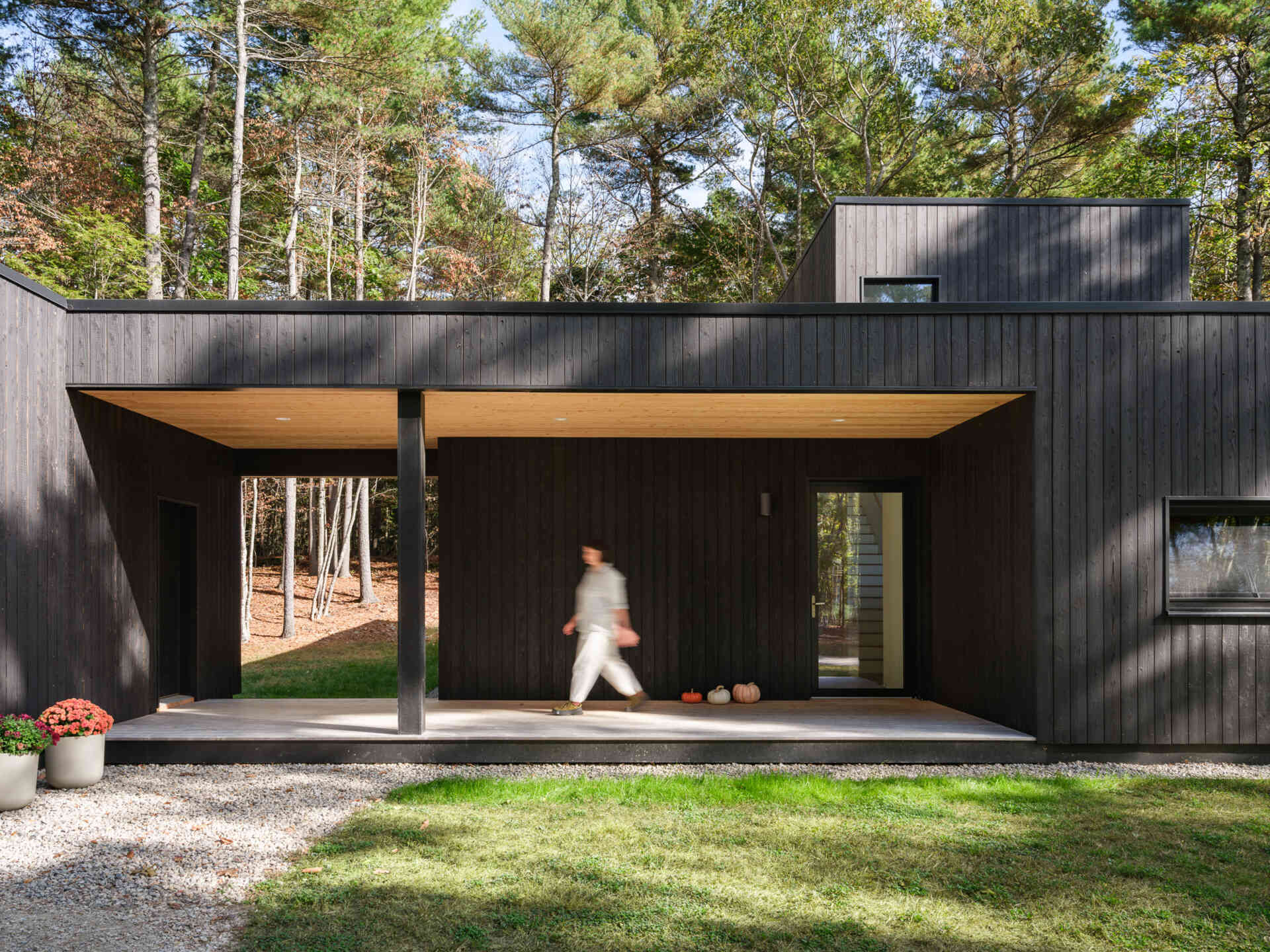 A covered porch, warm ash finishes, and natural light make the entryway of this Maine home feel welcoming and bright.