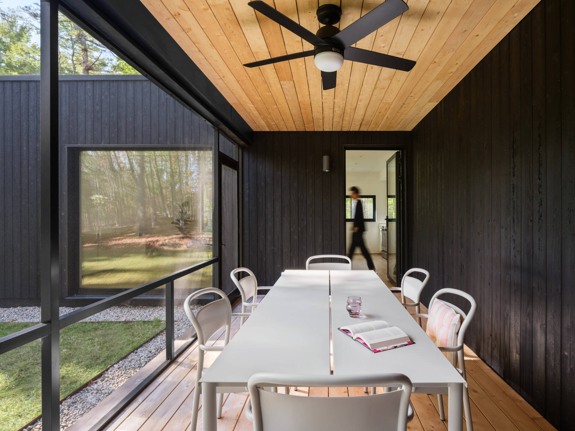 This Maine home uses black charred wood siding and dramatic floor-to-ceiling glass to create a modern exterior in the forest.