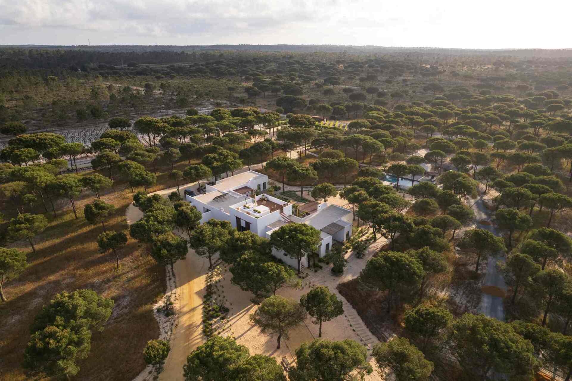 This contemporary villa in Comporta, Portugal by SabraB Architecture pairs crisp white architecture with pine forests, cork oaks, and minimalist interiors for a stunning indoor-outdoor living experience.