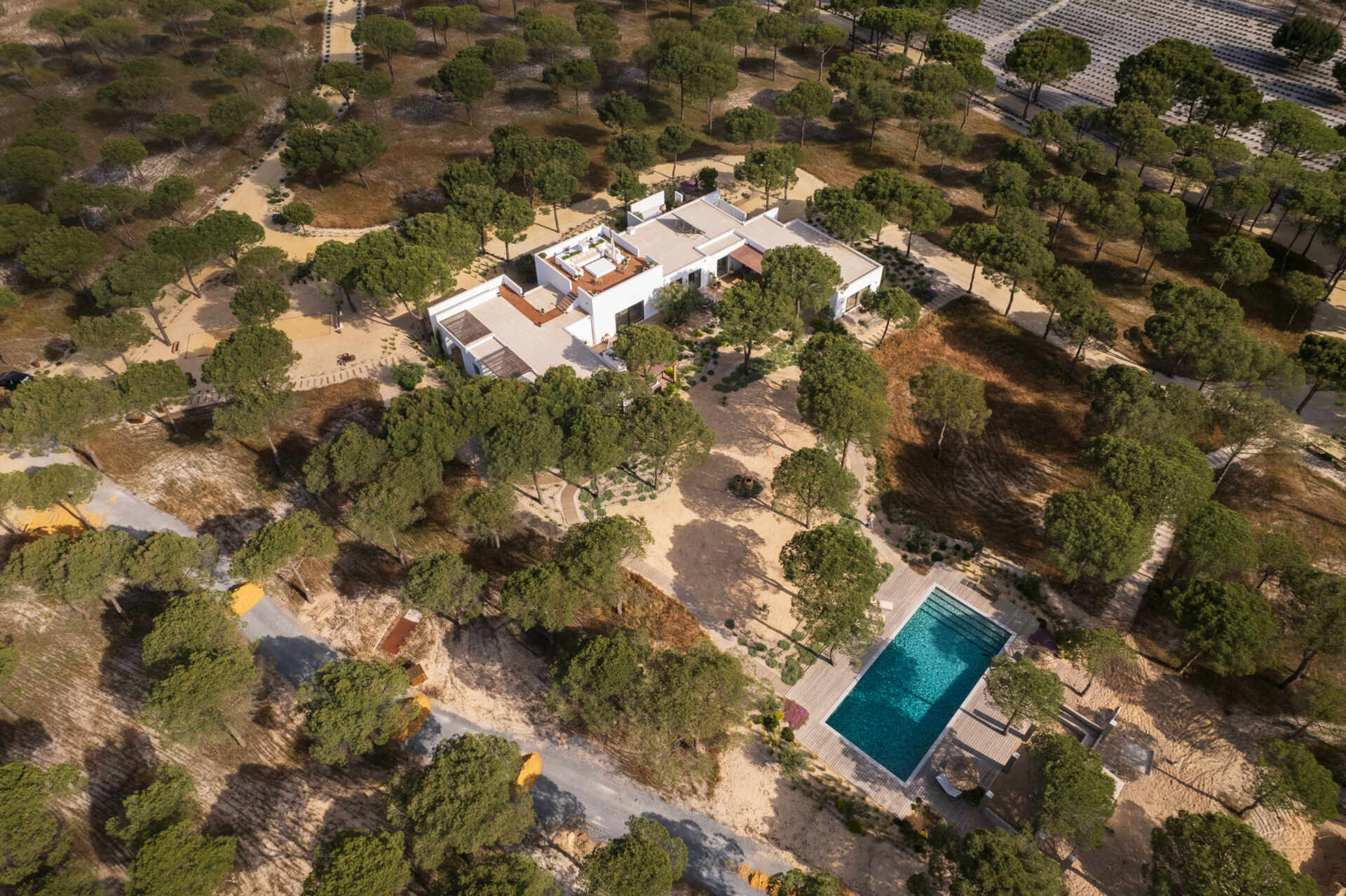 This contemporary villa in Comporta, Portugal by SabraB Architecture pairs crisp white architecture with pine forests, cork oaks, and minimalist interiors for a stunning indoor-outdoor living experience.