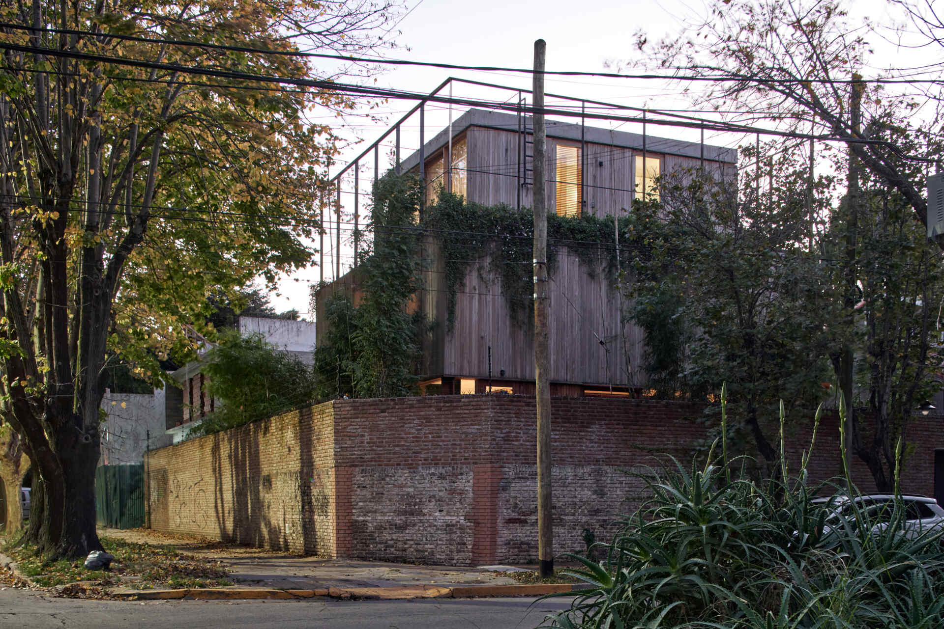A simple brick wall with a discreet gate creates privacy from the street while setting up a striking transition into the home.