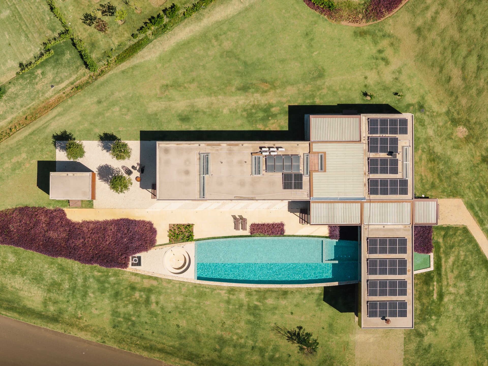 Casa Themis in Itu, Brazil transforms a sloping countryside site into a warm modern home with stone walls, wood cladding, and expansive outdoor living spaces designed for weekends with family and friends.